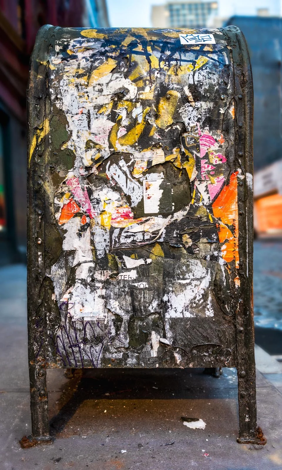 Fine art urban photography print of a public New York City mailbox covered in sticker slaps and graffiti. This photograph of street art collage is captured by contemporary photographer Barton Lewis.