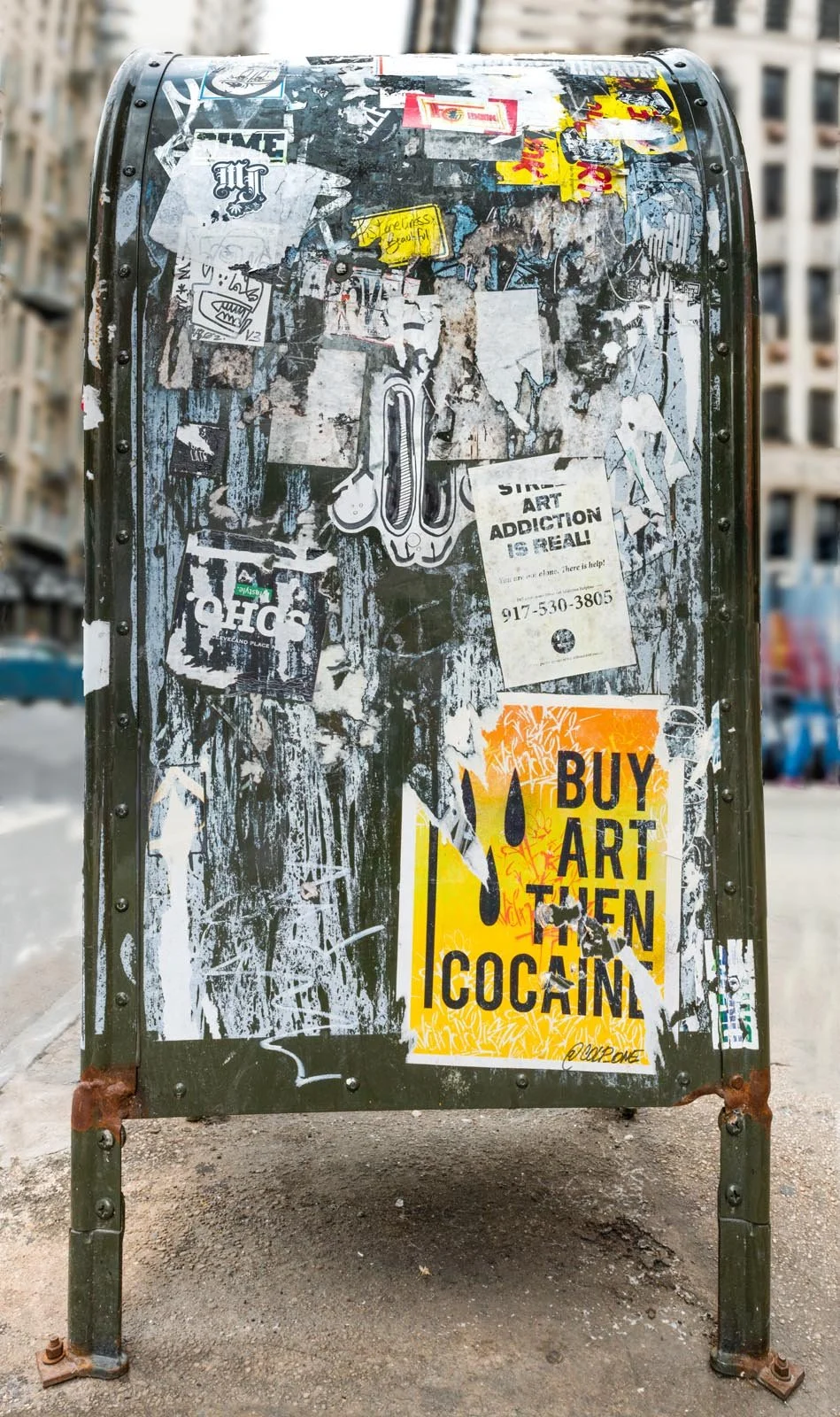 Fine art urban photography print of a public New York City mailbox covered in sticker slaps and graffiti. This photograph of street art collage is captured by contemporary photographer Barton Lewis.