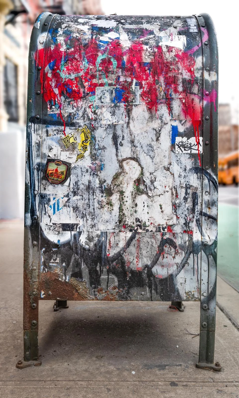 Fine art urban photography print of a public New York City mailbox covered in sticker slaps and graffiti. This photograph of street art collage is captured by contemporary photographer Barton Lewis.