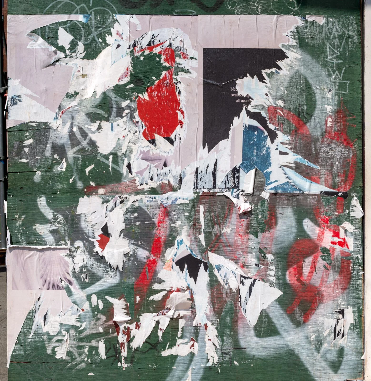Fine art urban photography capturing decaying advertising posters on a plywood construction site fence. The composition isolates layers of shredded commercial paper, weathered textures, and accidental street art by Barton Lewis.