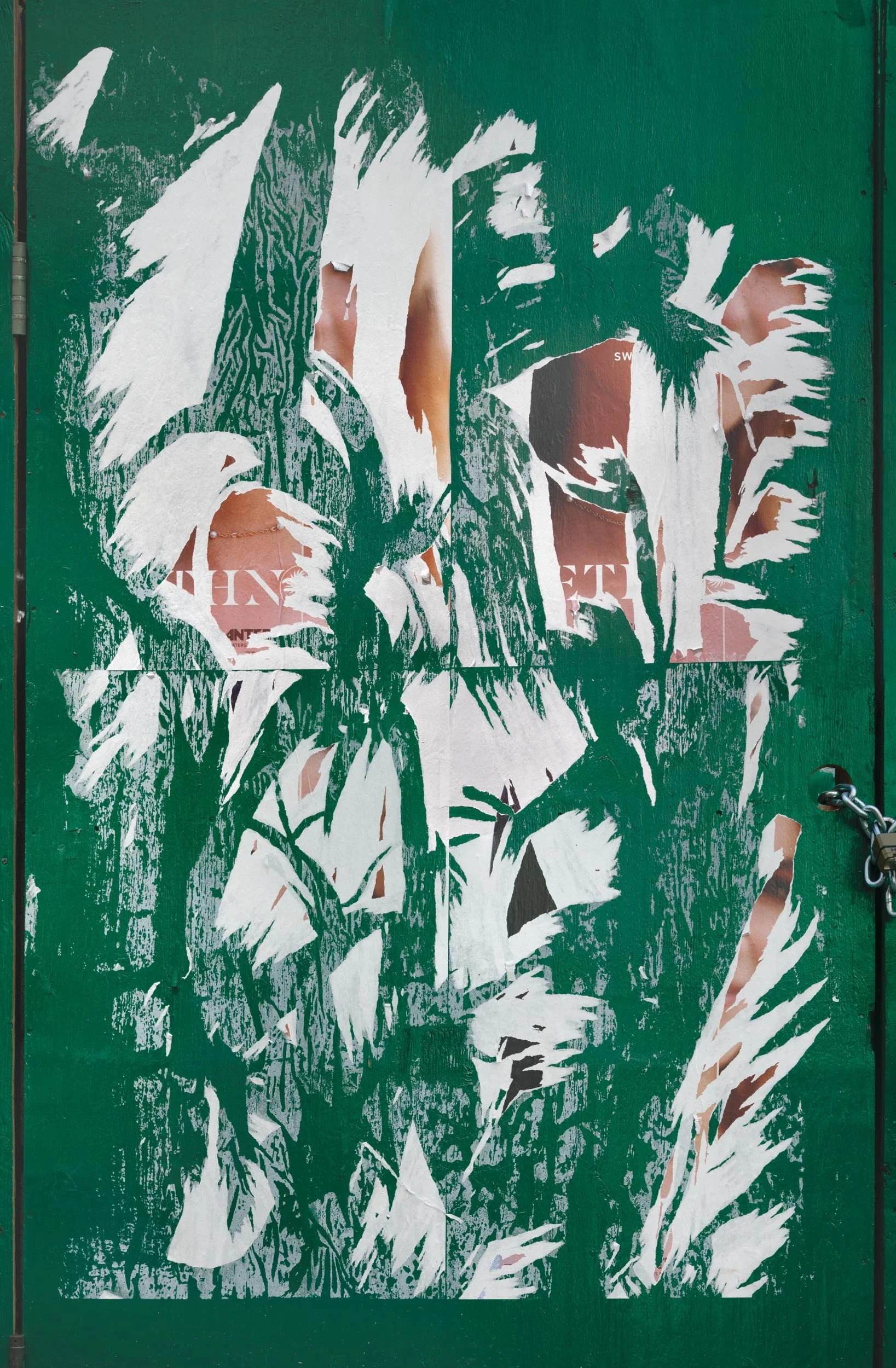 Fine art urban photography capturing decaying advertising posters on a plywood construction site fence. The composition isolates layers of shredded commercial paper, weathered textures, and accidental street art by Barton Lewis.