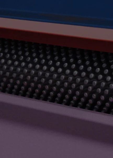 Close-up of a black textured surface with small, raised circular bumps, possibly part of a machine or equipment.