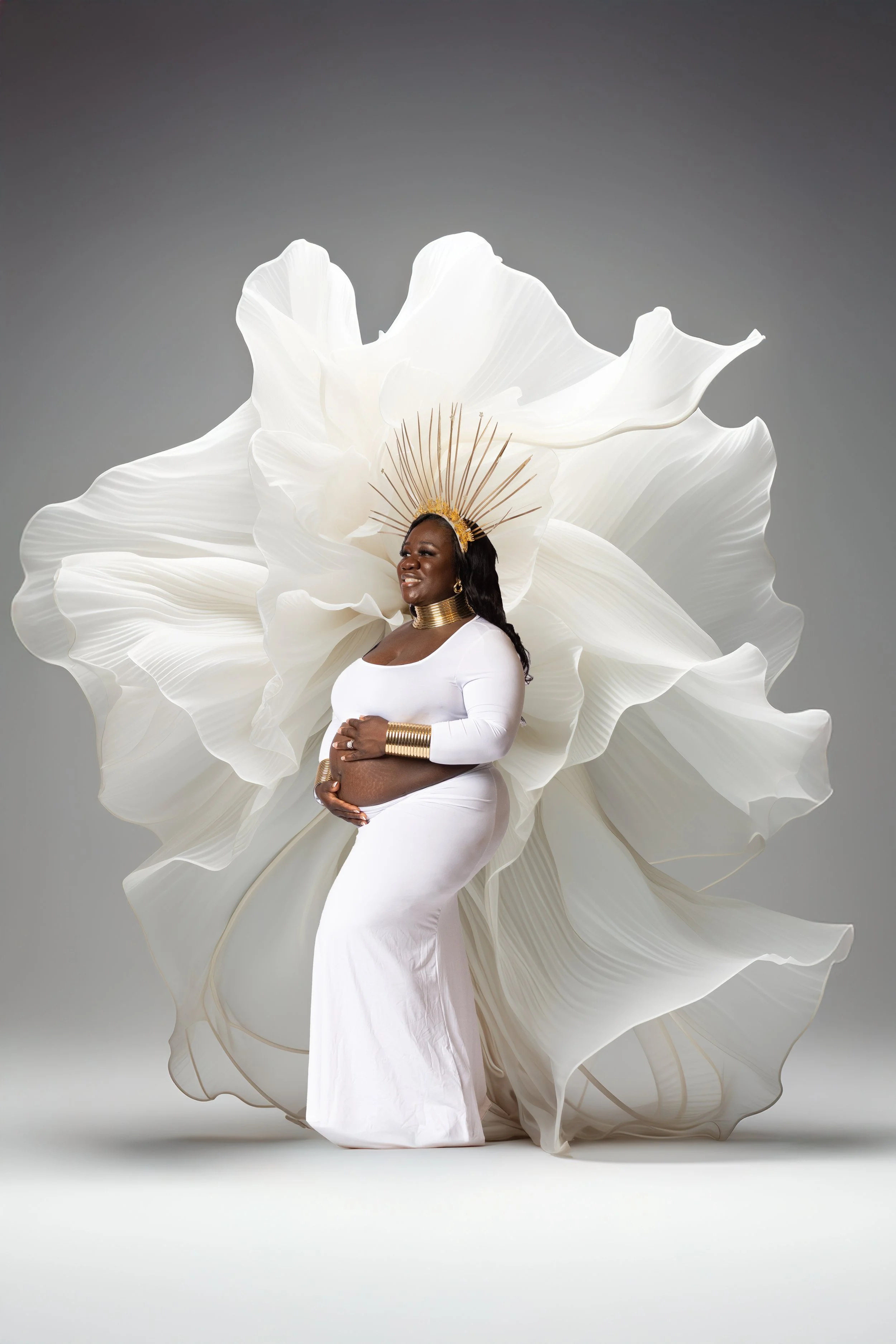 Artistic maternity photography with dramatic lighting and sheer fabric in Cincinnati Ohio studio