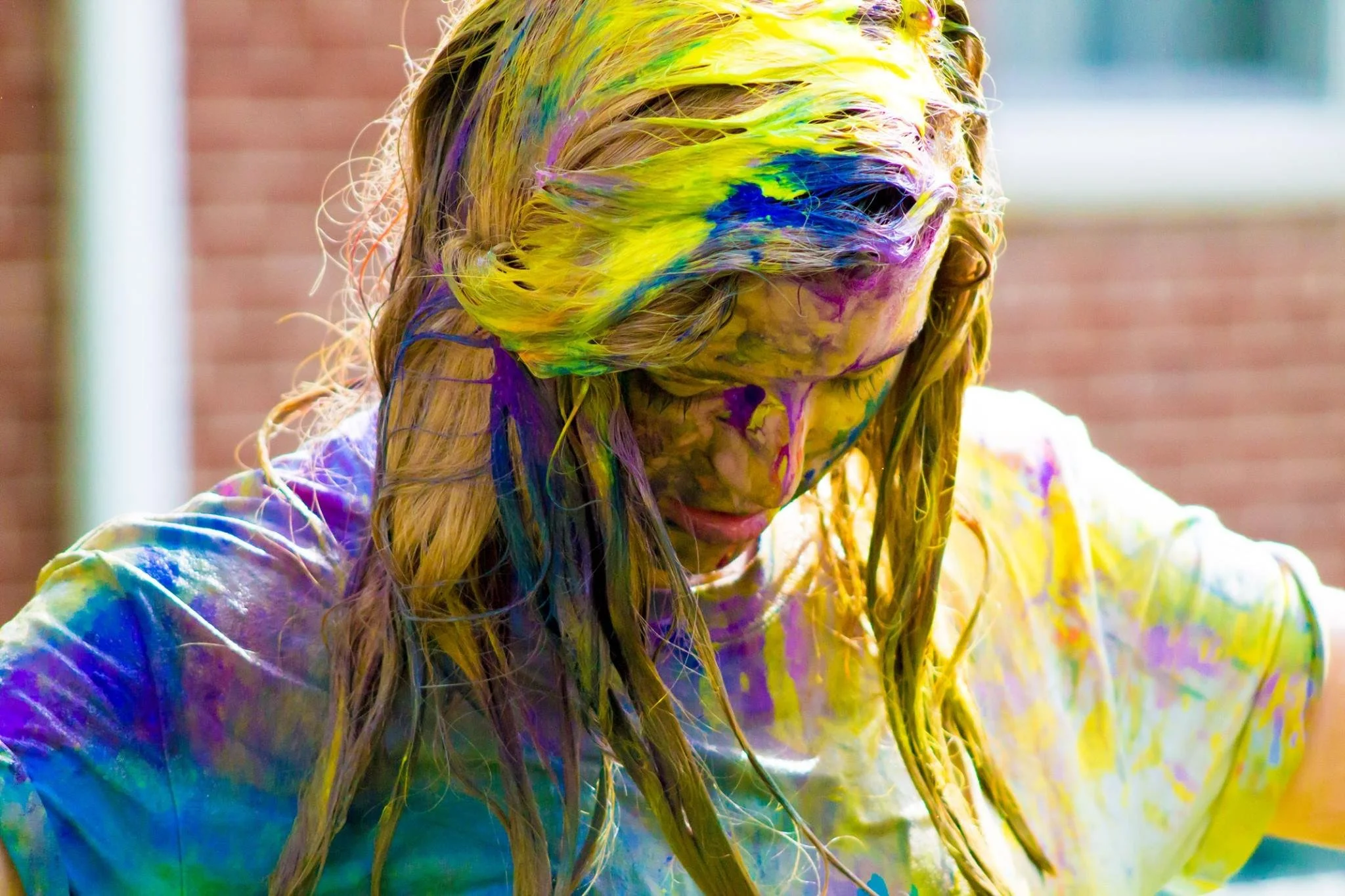 Senior covered in colorful paint splatter during a creative messy paint senior portrait session in Cincinnati