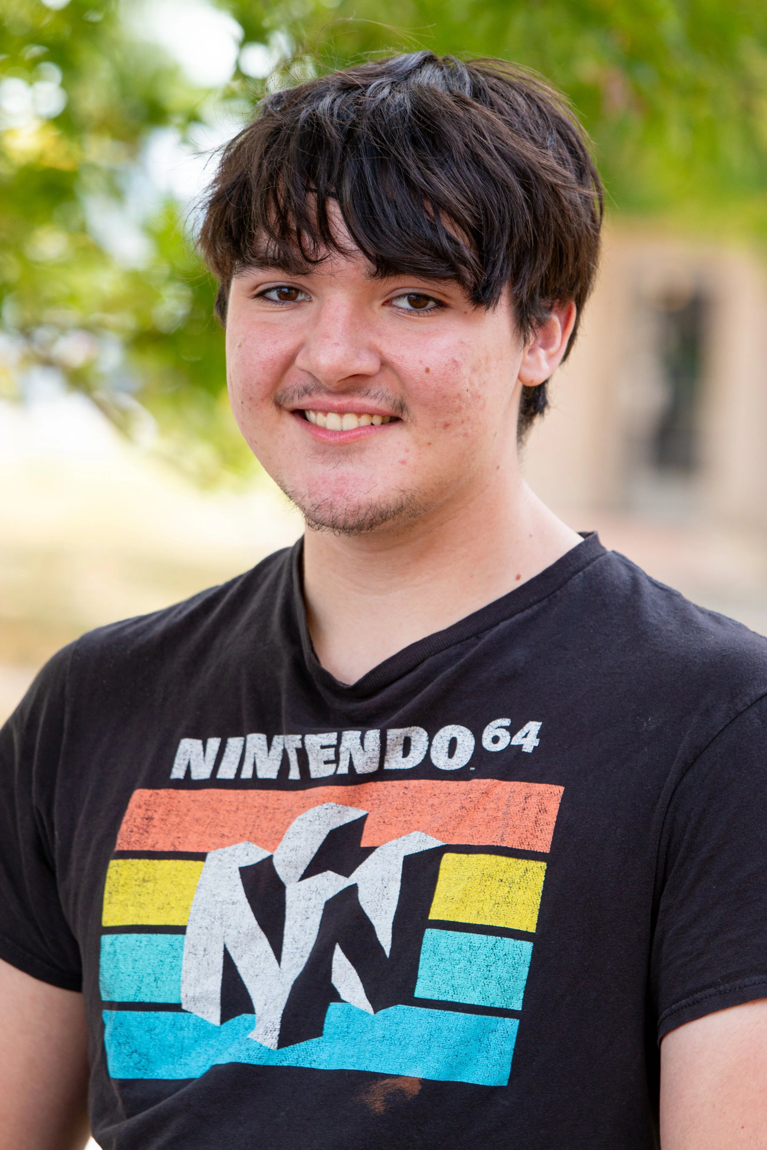 Student in Nintendo 64 t-shirt smiling for outdoor school portrait