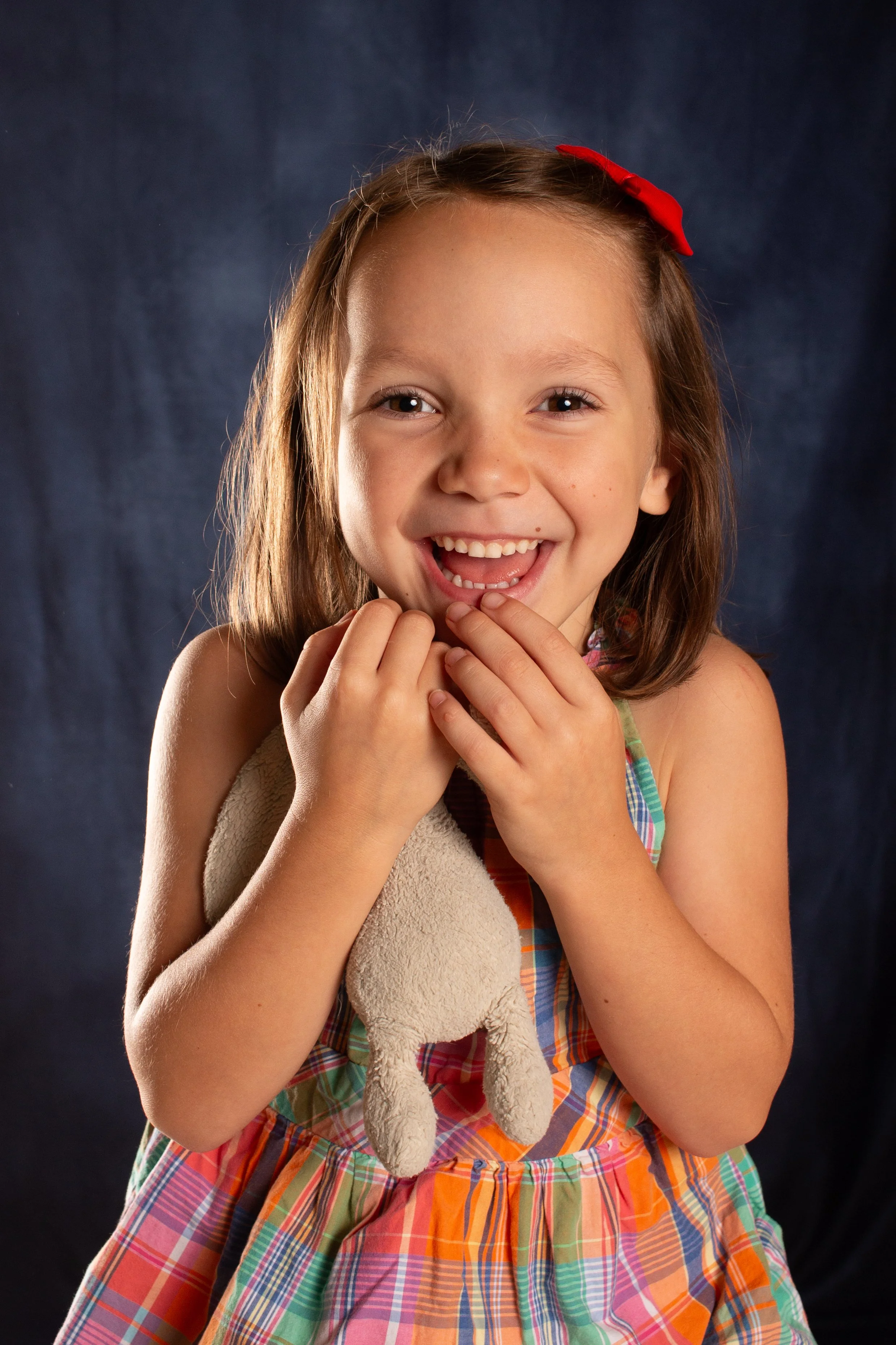  Little girl holding bunny during school photos on blue background 