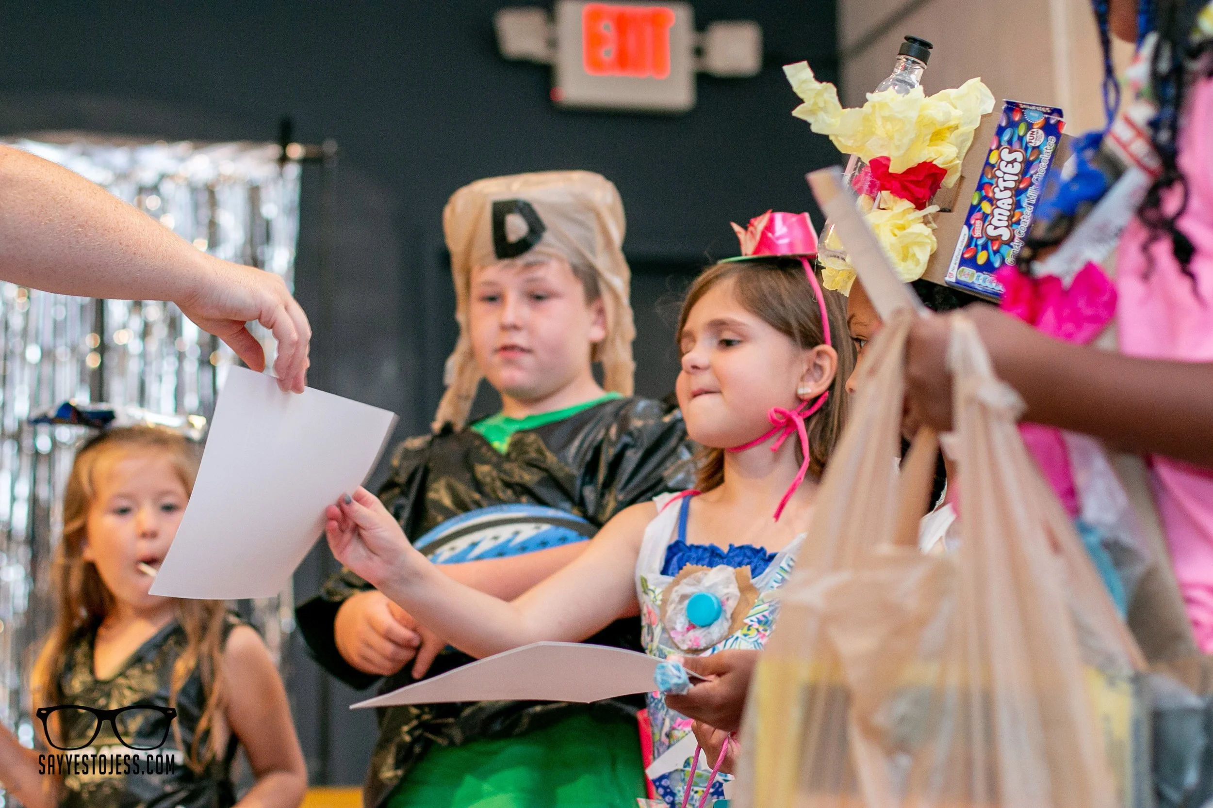 Kids receiving awards on the trashion show runway at Red Balloon Cafe