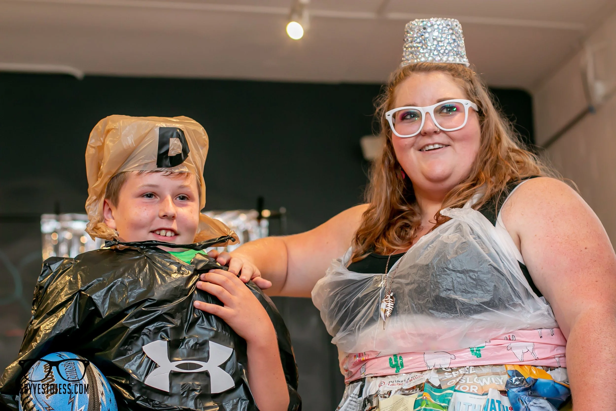Jess Summers posing with a young boy in matching recycled outfits at the kids trashion show in Cincinnati
