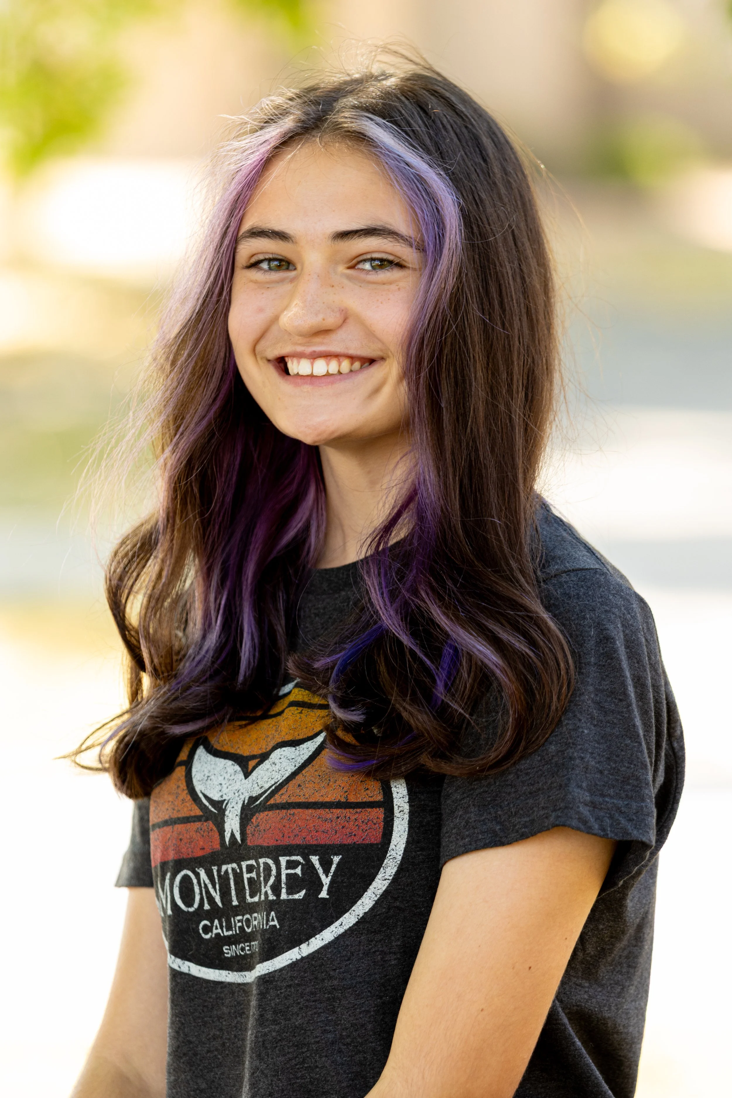 Student smiling for school picture day portrait with dark blue backdrop