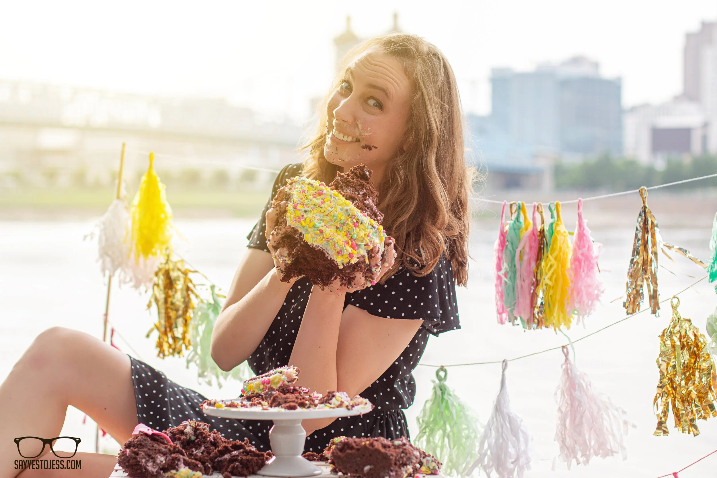 Adult birthday cake smash portrait on the Cincinnati riverfront with a confetti sprinkle cake