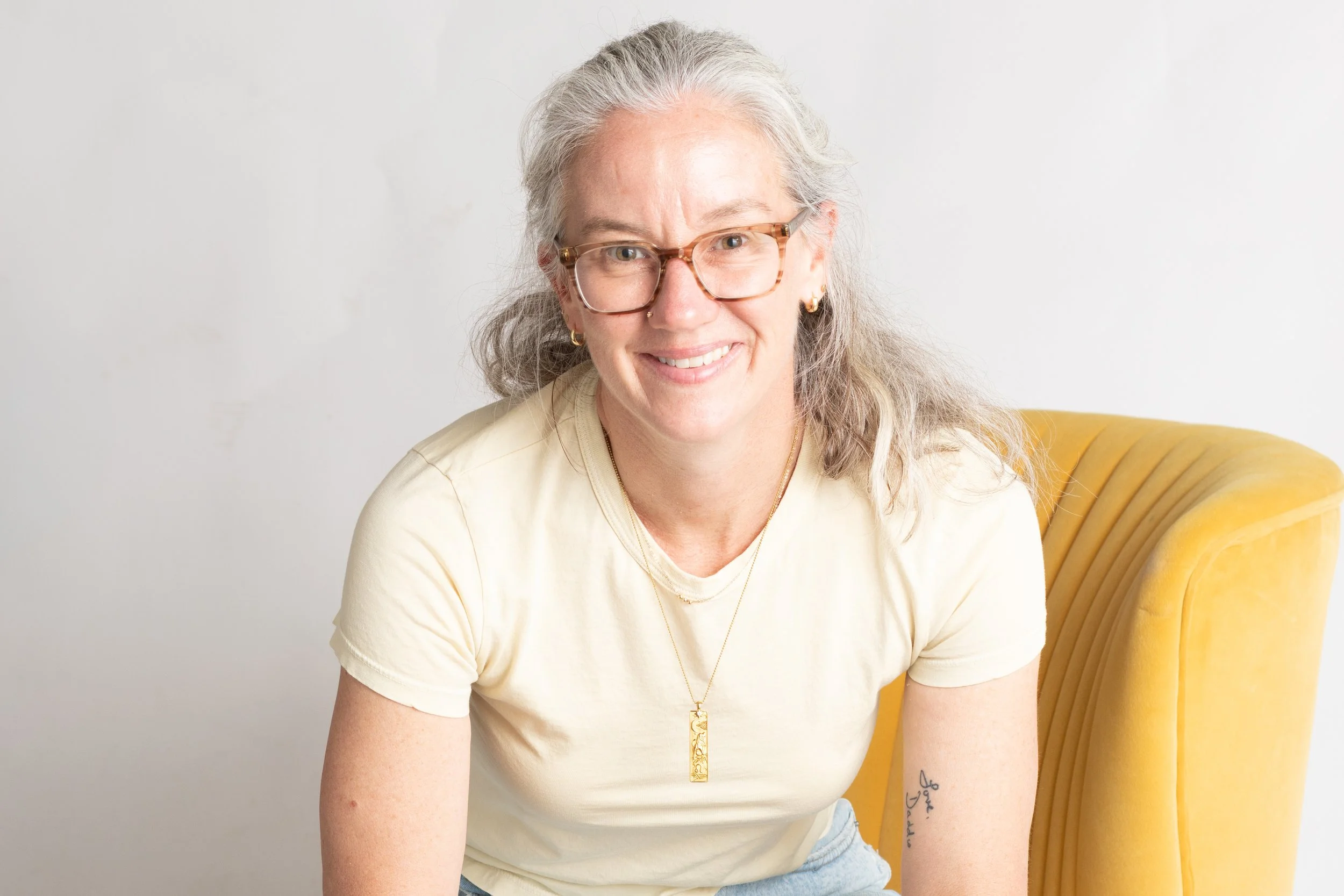 Warm professional headshot of a woman with silver hair and glasses, photographed at Say Yes to Jess studio in Cincinnati.