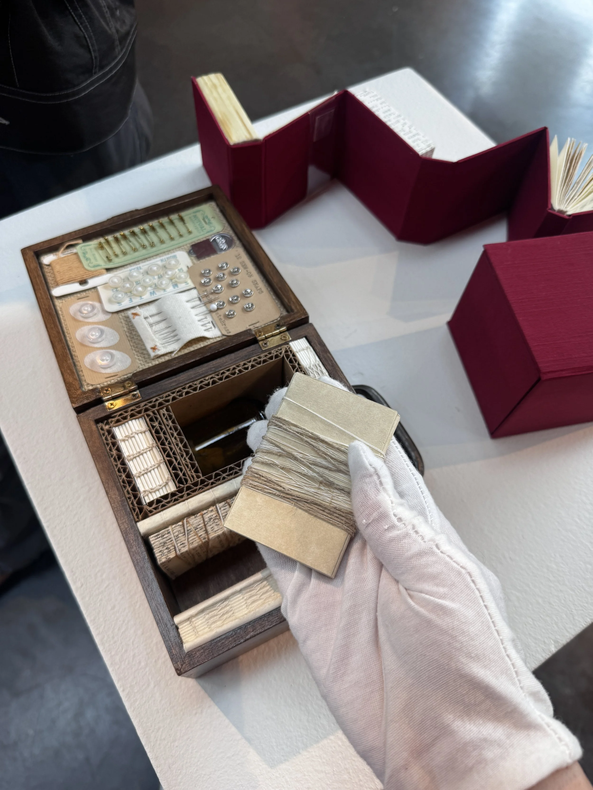  ﻿﻿﻿holding a part of Naomi Kasumi,   Memory Collection #15 memento,   2013. Mixed media (found bookpages, trimmed/leftover paper, found objects (buttons), fabric, linen thread, tea-bag, beeswax, found medicine bottle, digital print, typewriter).  