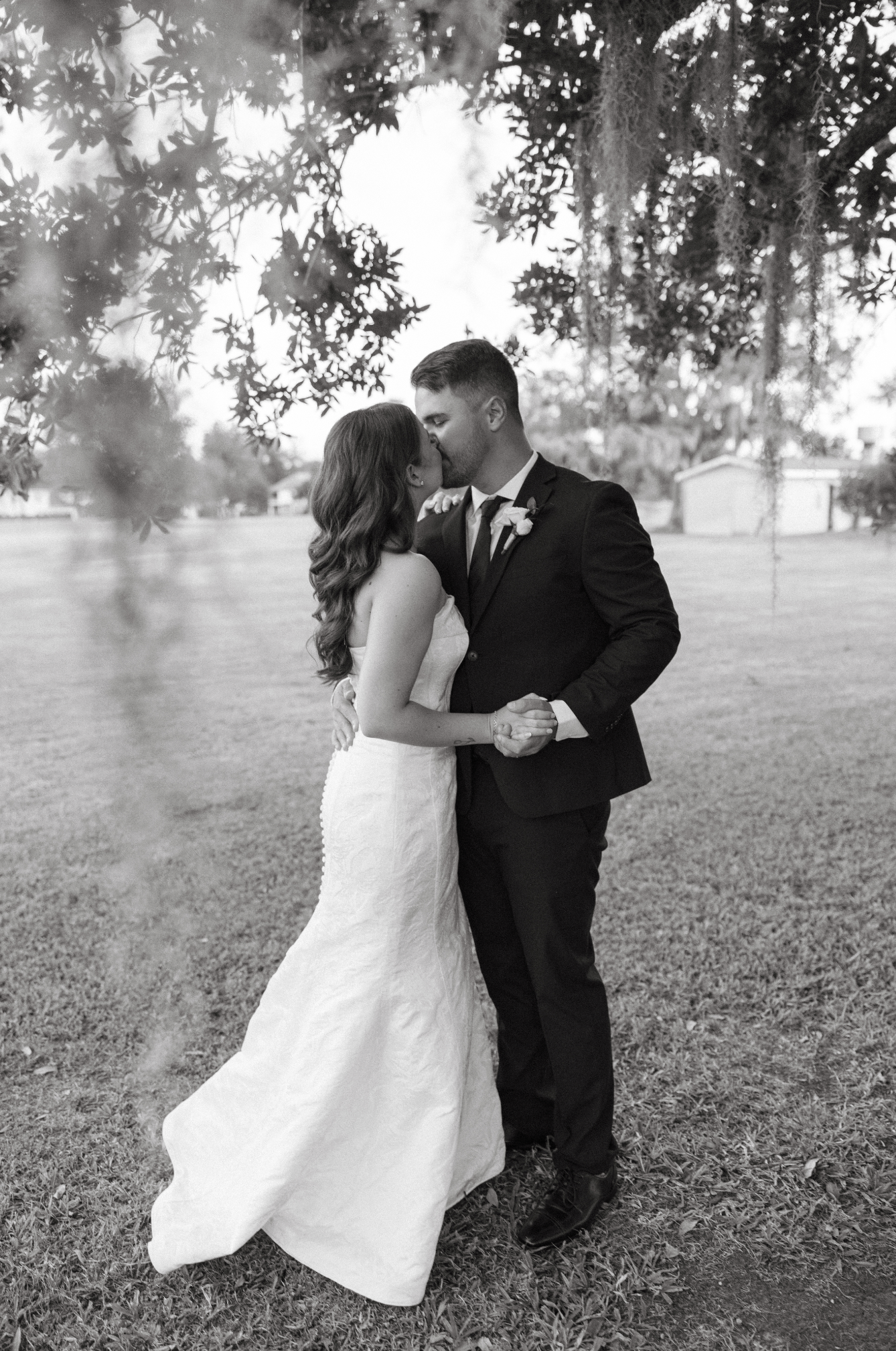 Bride and Groom kissing underneath an oak tree
