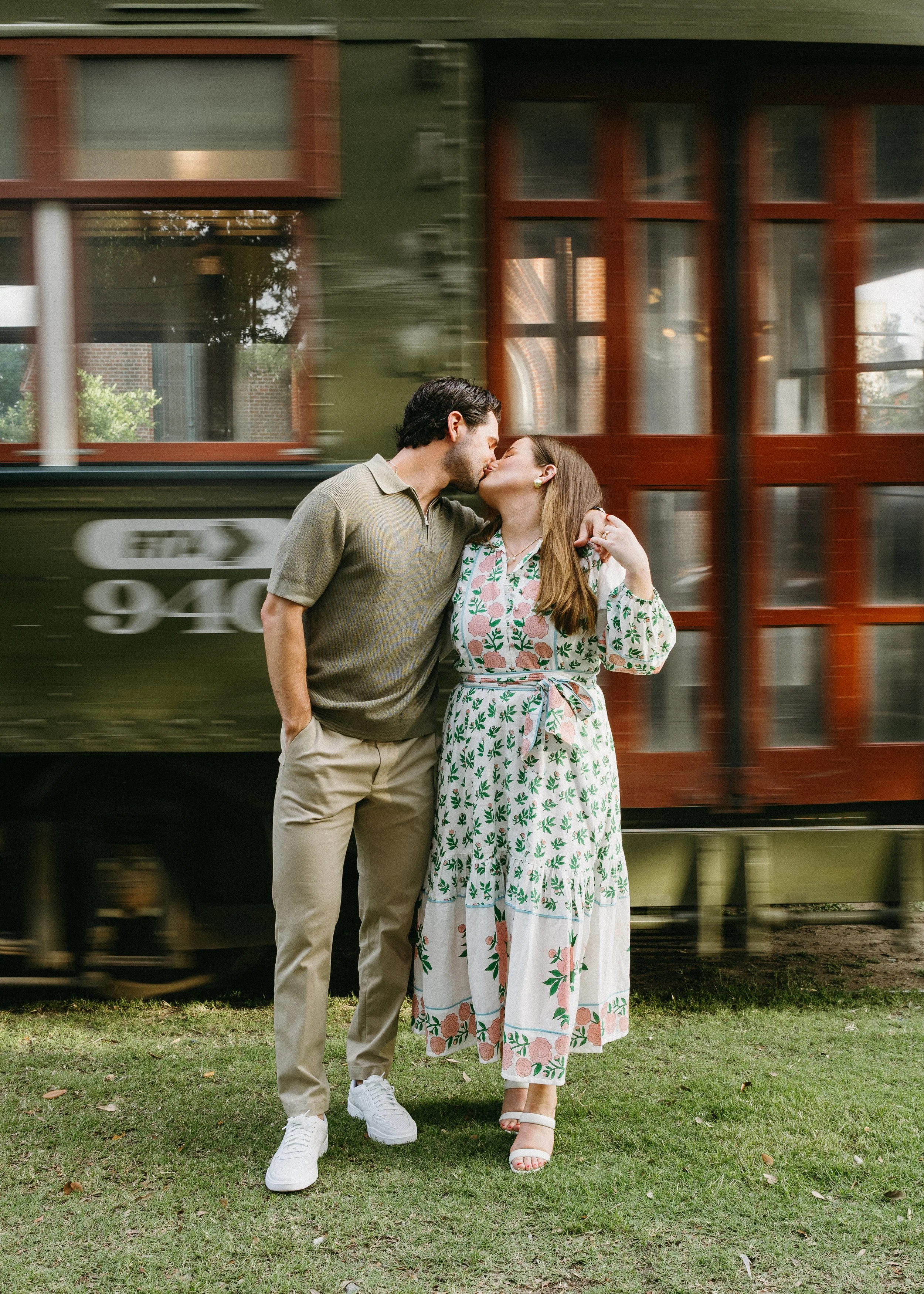 Couple kissing in front of a moving streetcar in New Orleans