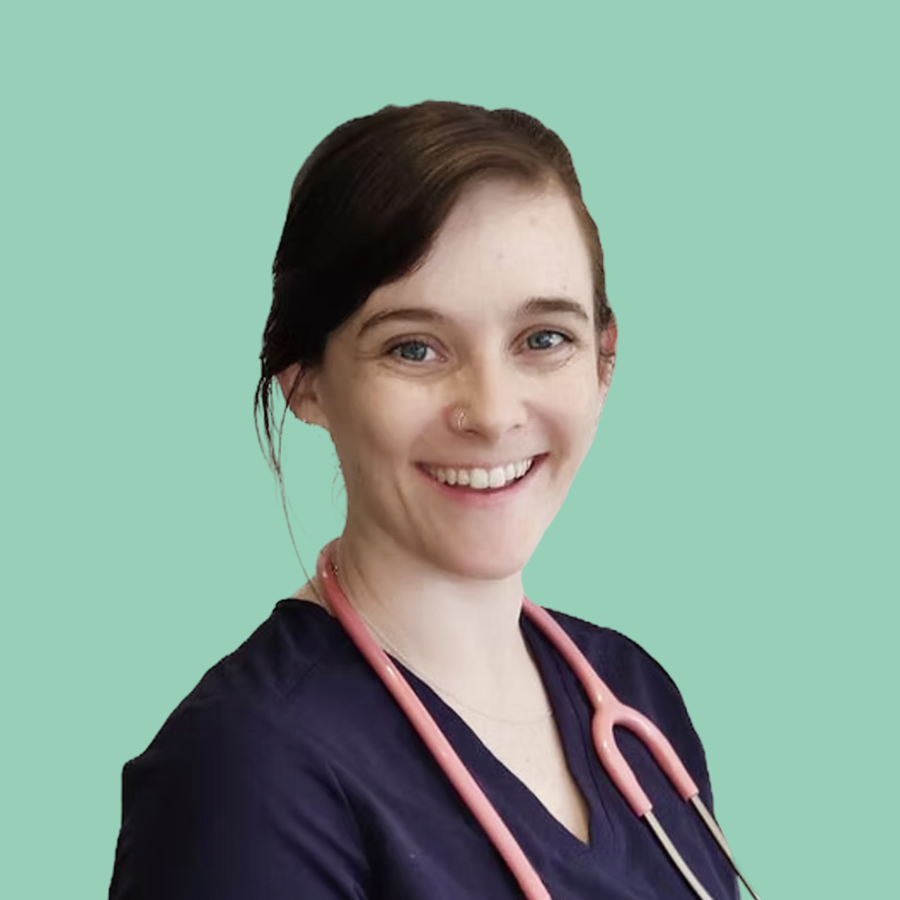 Smiling female healthcare professional with dark hair, wearing navy scrubs and a pink stethoscope around her neck, against a light green background.