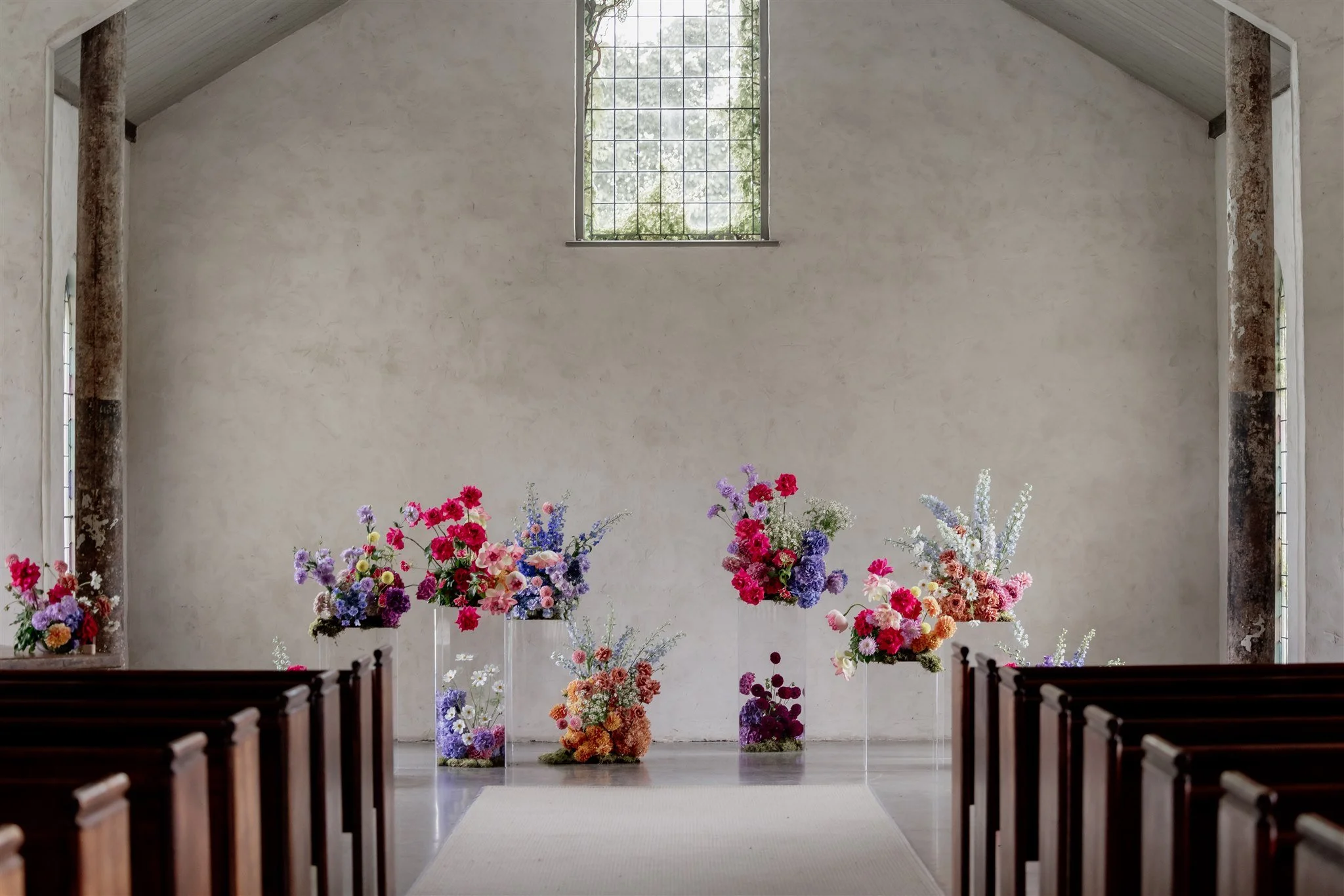 Interior of a church with floral arrangements in colorful vases.