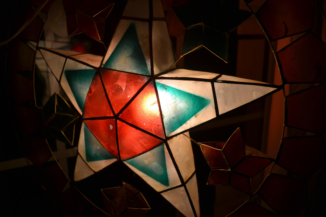 Close-up photo of a white, green, and red parol in the dark