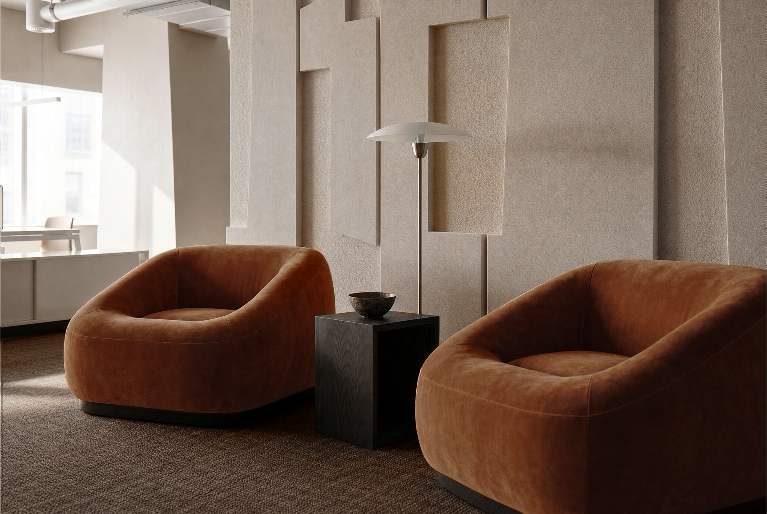 Modern office lounge area with two round orange-brown armchairs, a small dark side table with a bowl, a tall white floor lamp, textured beige wall panels, large windows in the background, and a carpeted floor.