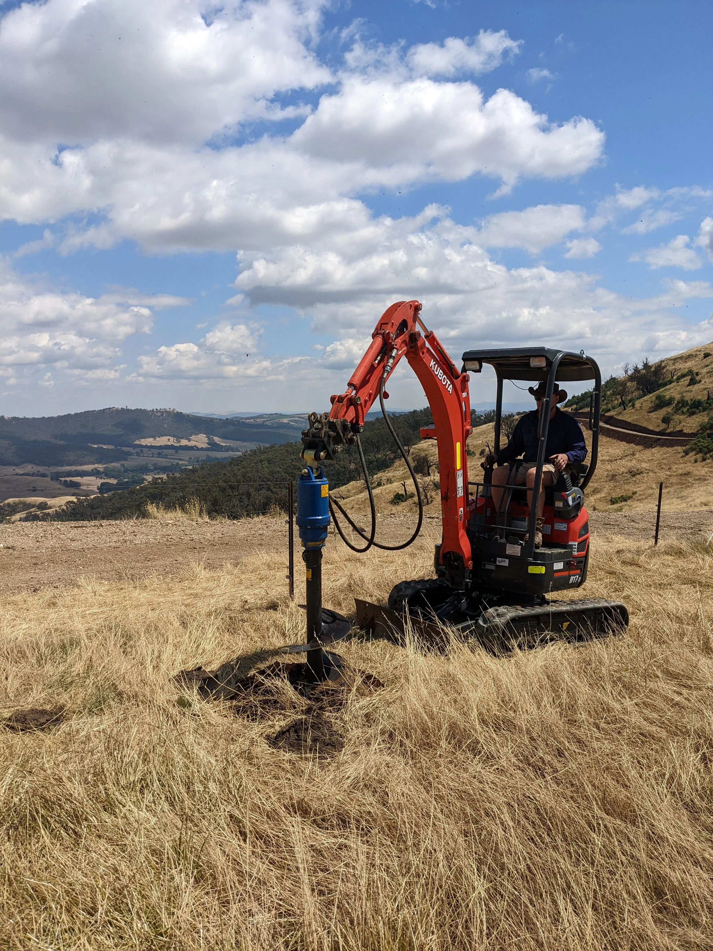 Marty digging holes for trees with a mini excavator