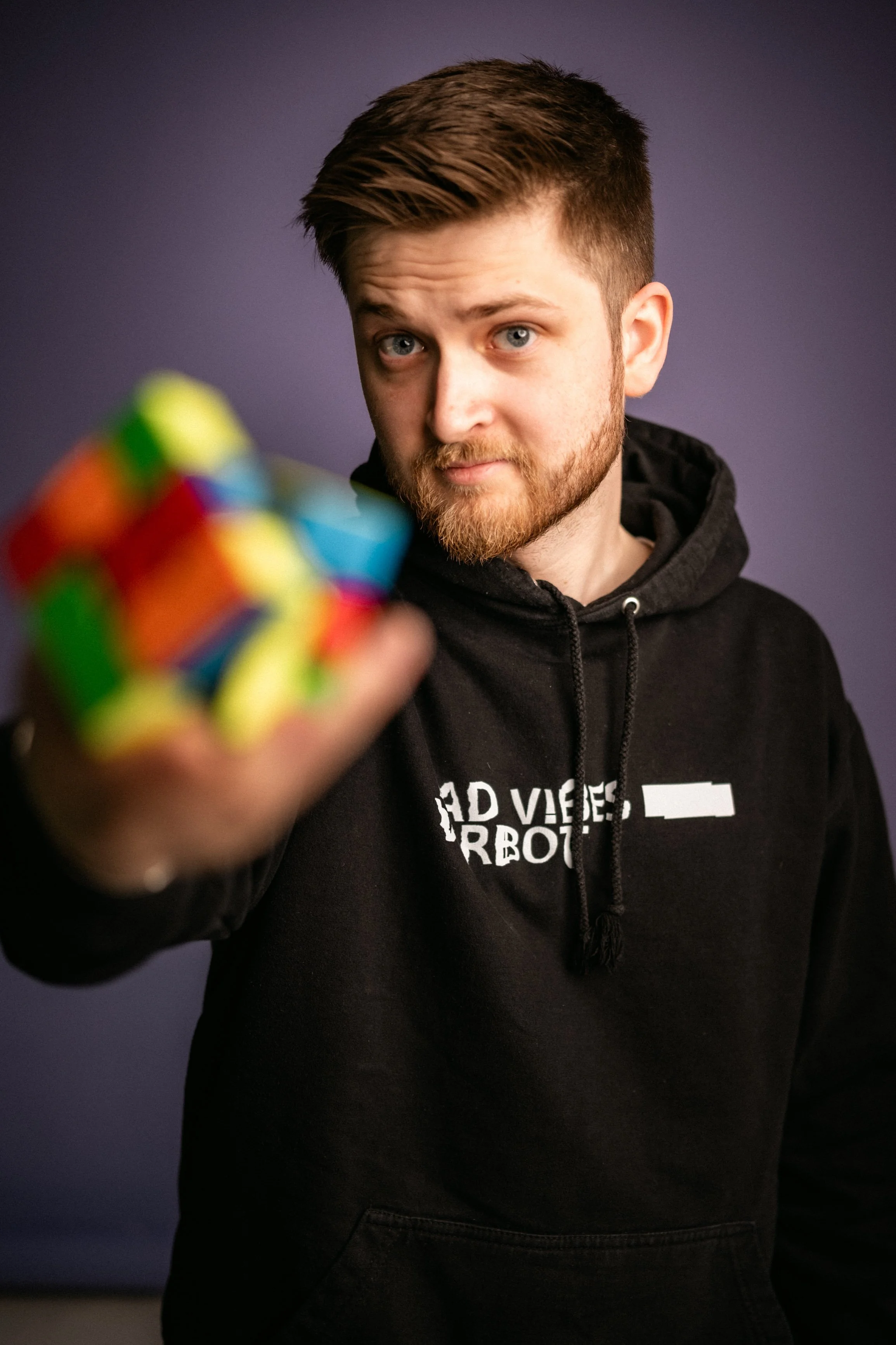 Person mit Rubik Cube in der Hand, Porträt, schwarzer Hoodie
