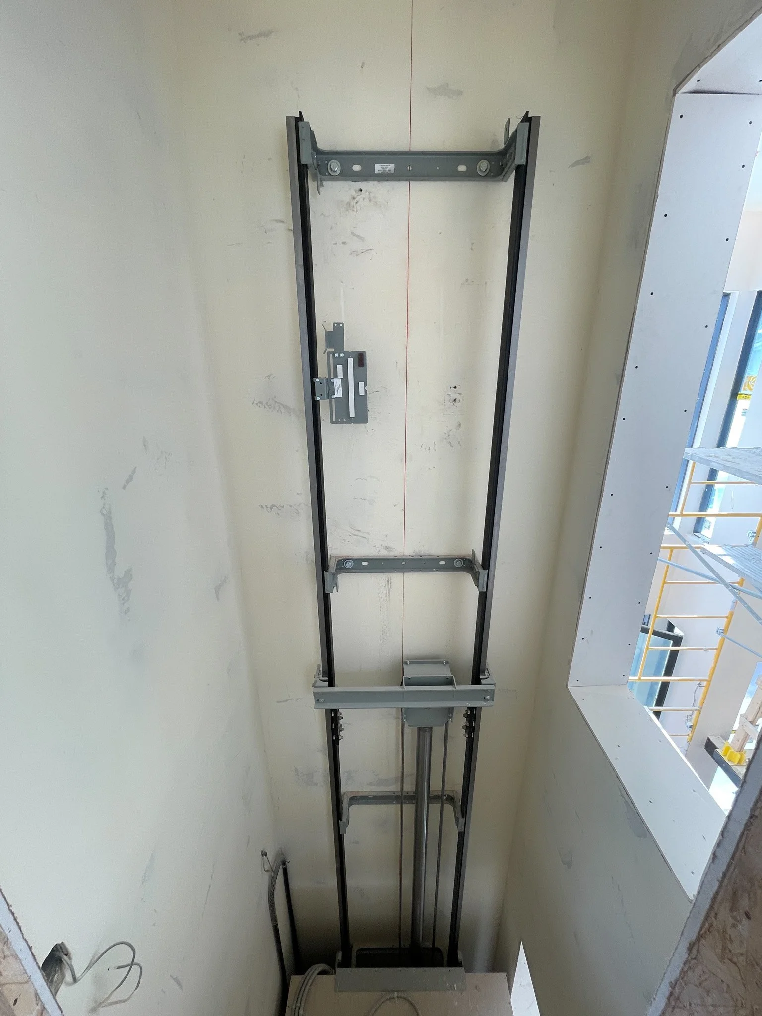 Elevator shaft with metal guide rails and mechanical components, under construction
