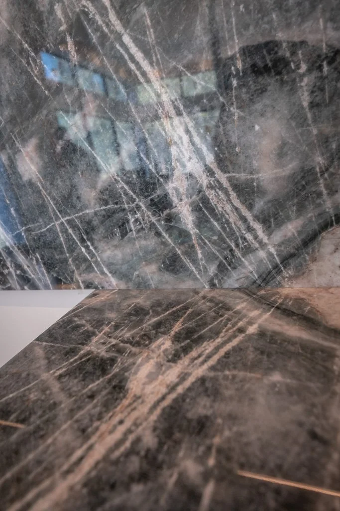 Close-up of a dark marble surface with light veining.