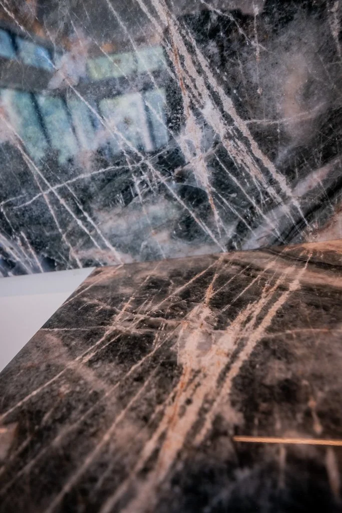 Close-up of a black marble surface with white and brown veining.