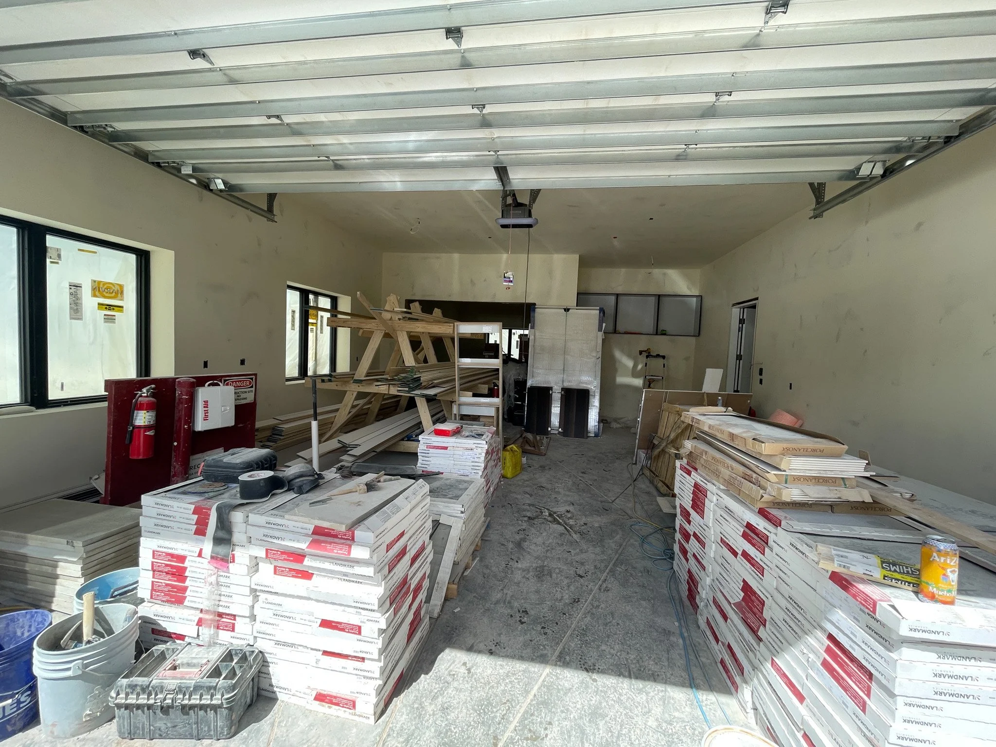 Interior view of a construction site showing drywall, wood framing, and construction materials.