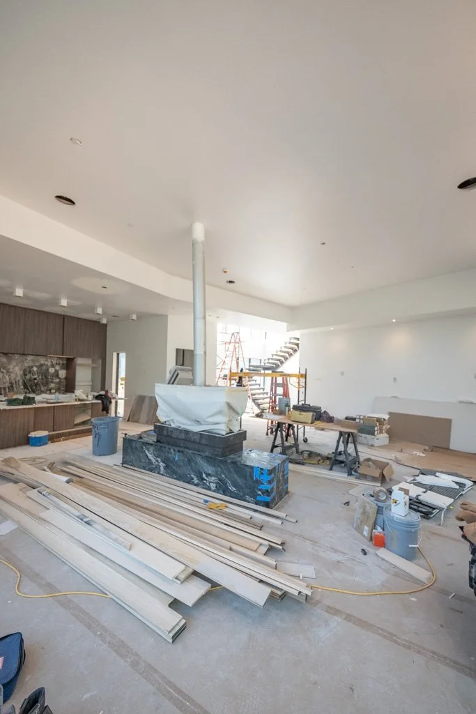 Interior of a building under renovation with construction tools, materials, and scaffolding.