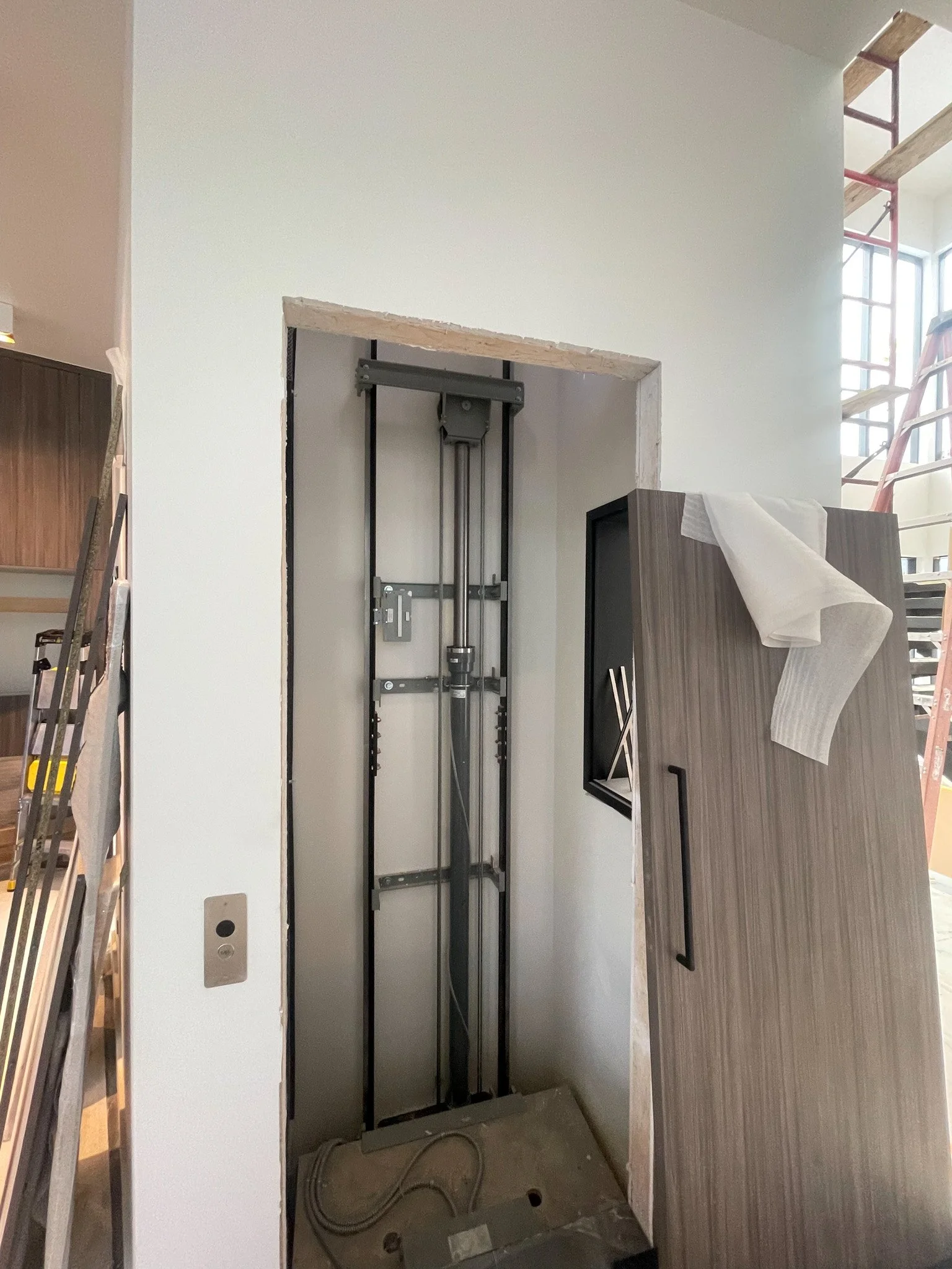 Elevator shaft under construction inside a building, with construction tools and materials around.