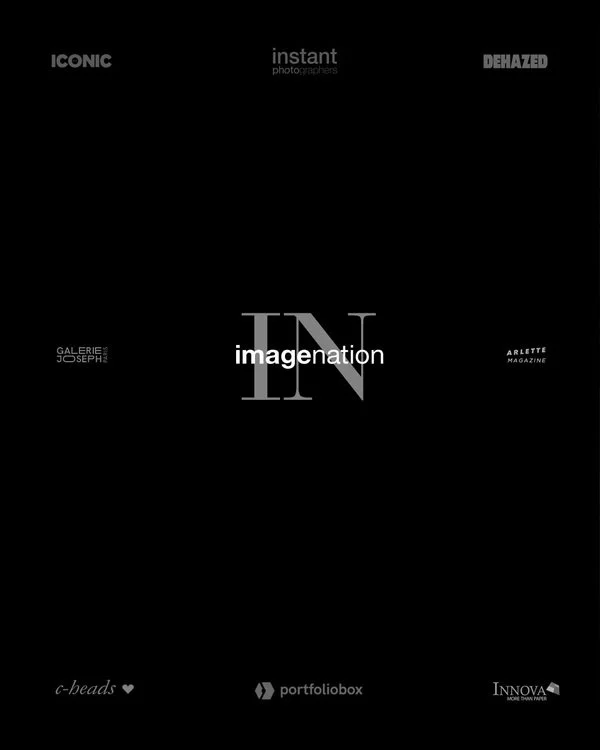 Copertina di una rivista con sfondo nero, vari loghi e testi in bianco e grigio, con la parola centrale "imagination" e "IN" in evidenza.