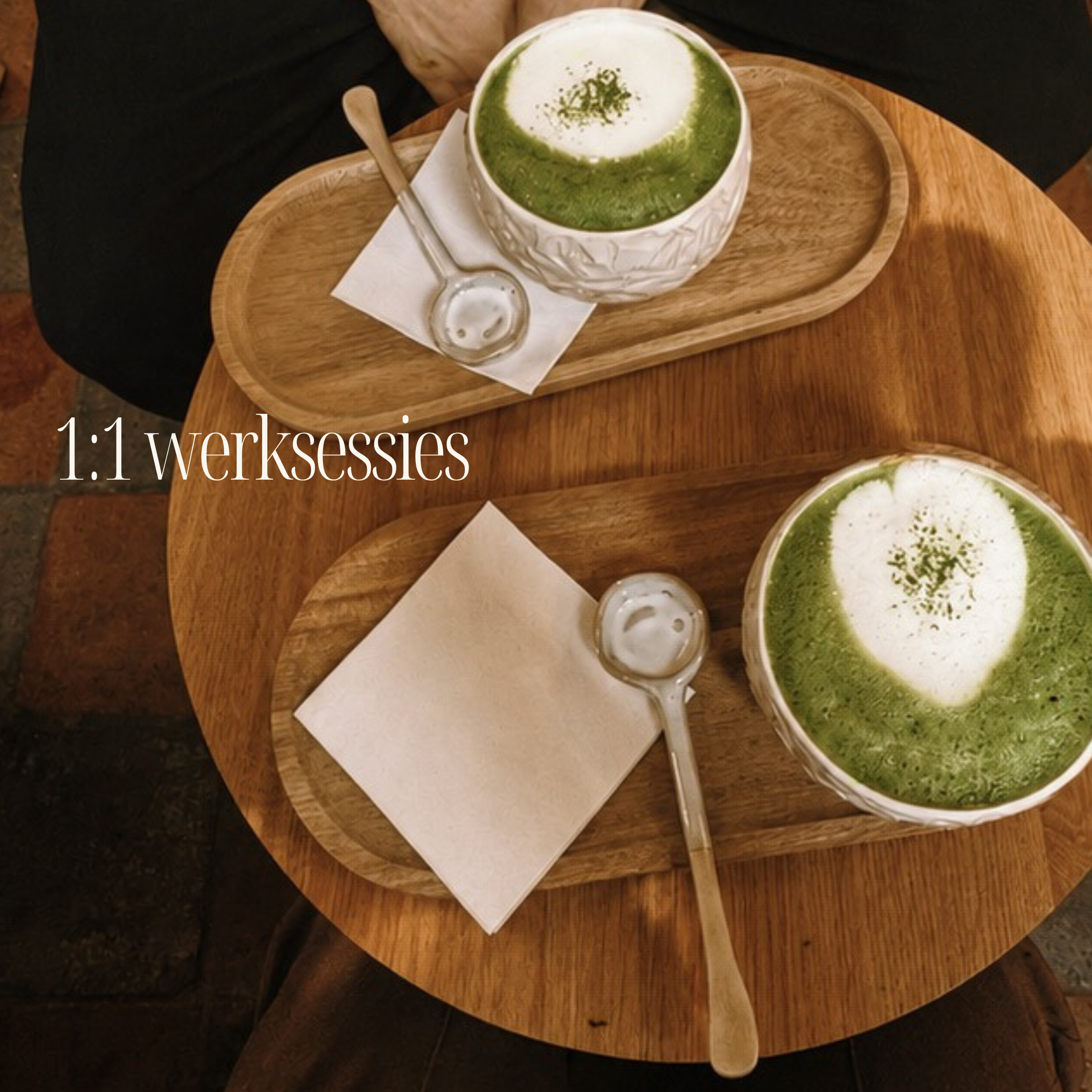 Een groene thee latte in een witte mok met een houten lepel naast op een houten dienblad.