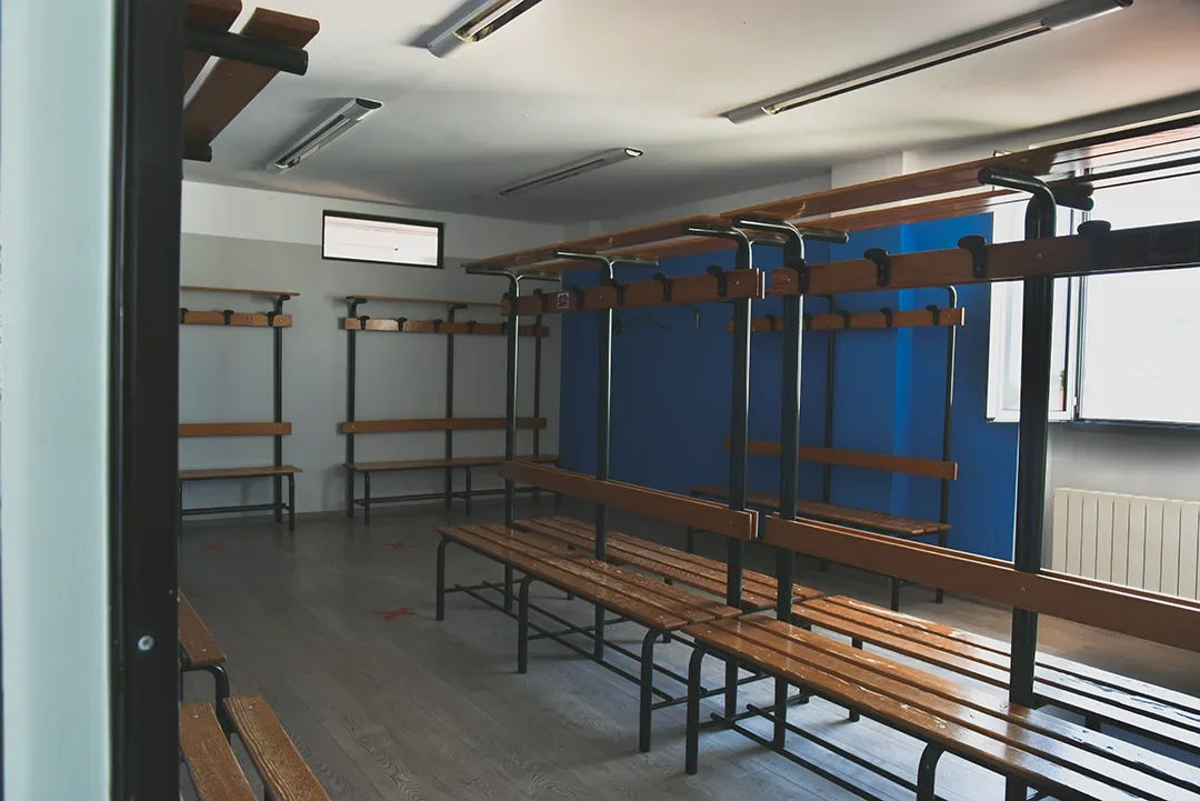 Spogliatoio scolastico con panche di legno e scaffali