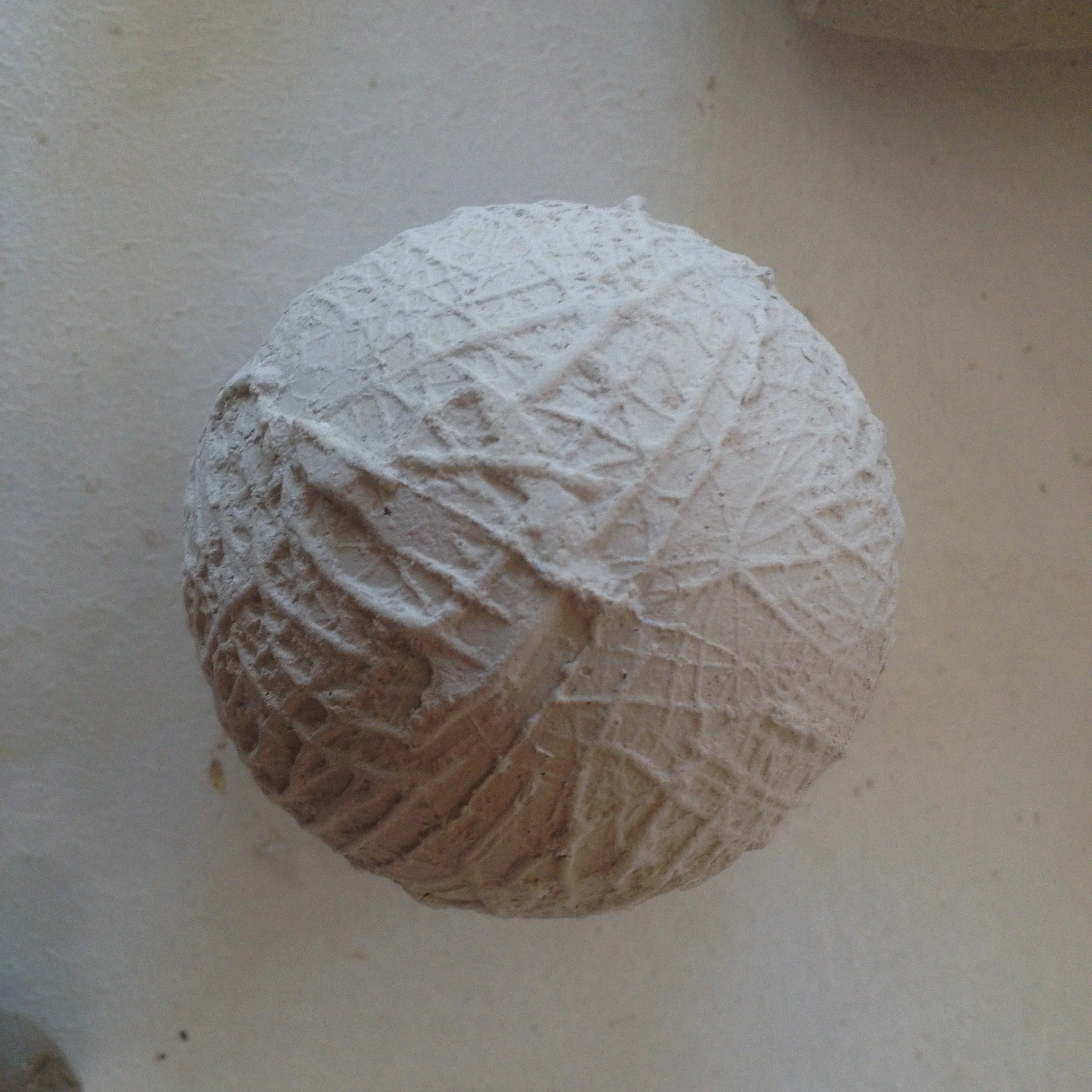 A ball of white modeling clay with textured patterns and imprints on its surface.