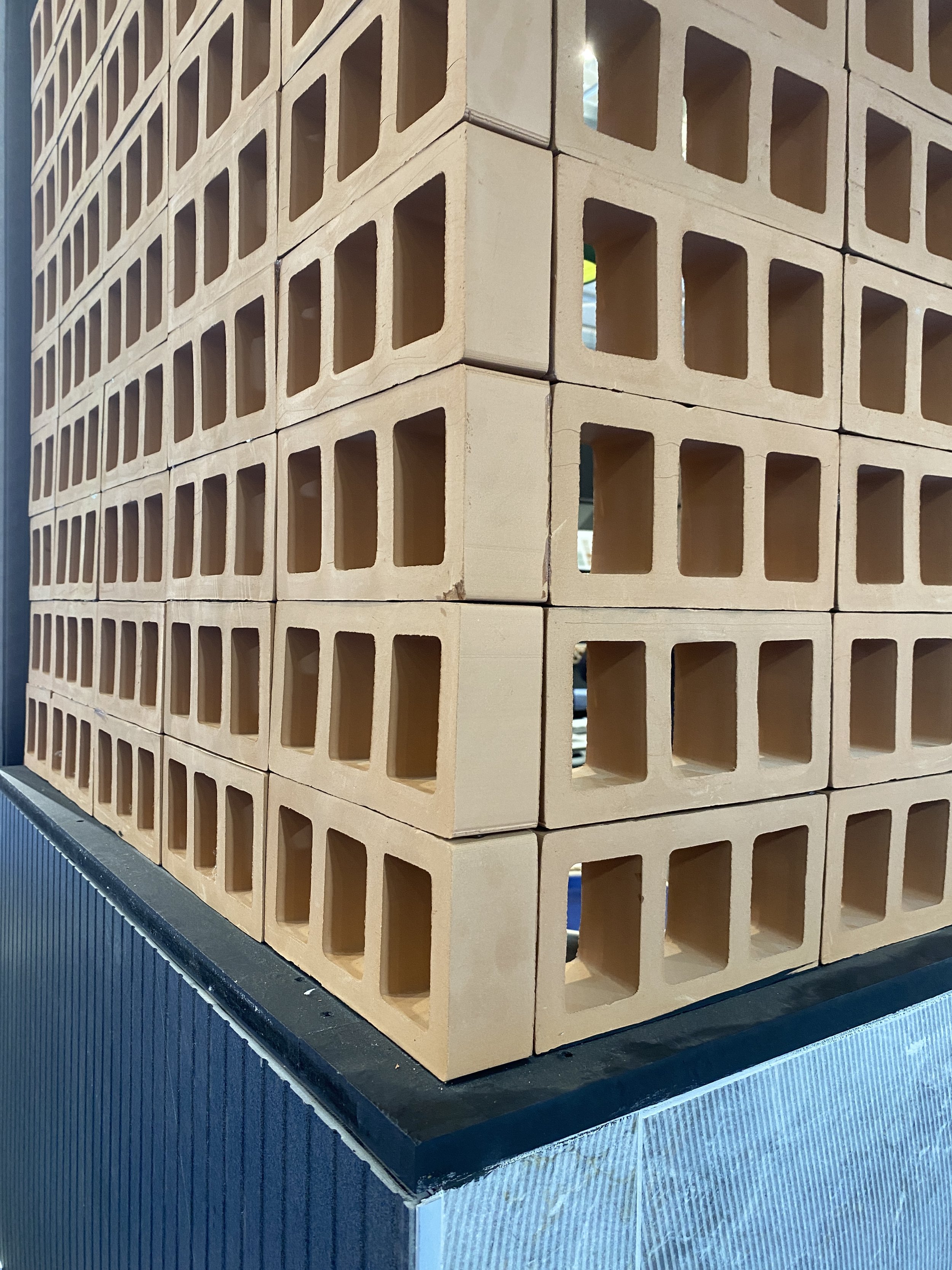 Stacked beige cinder blocks on a black and silver table surface.