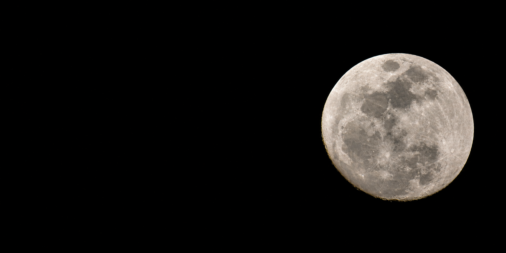 A full moon in a dark night sky, showing detailed surface features and craters.