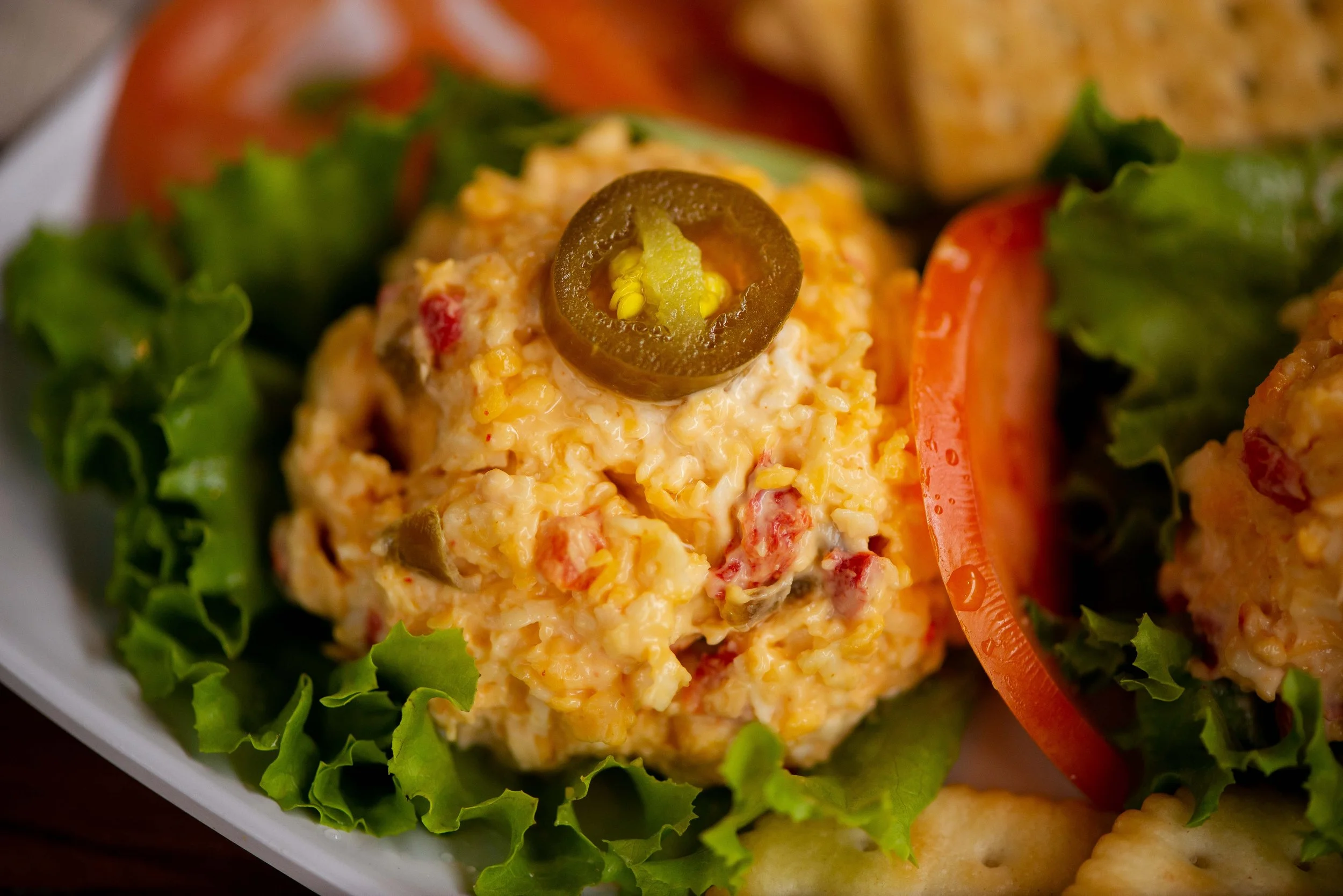 Garnish with a touch of class by placing a slice of jalapeno on top of the mounded pimento cheese.