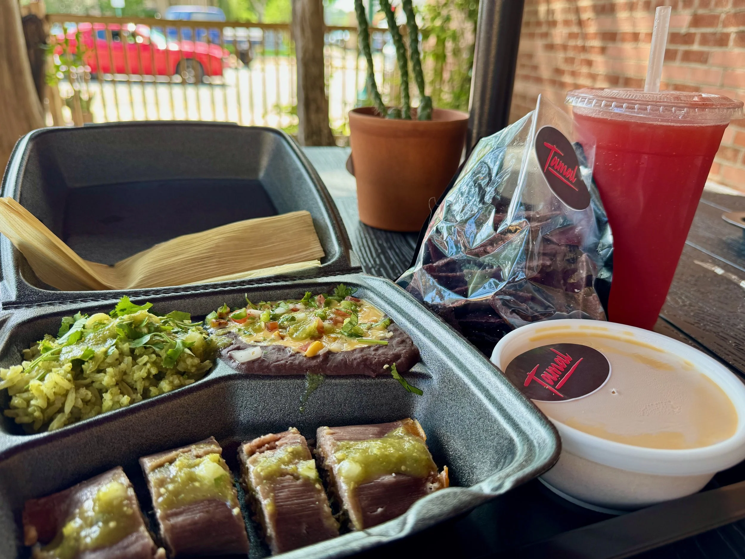 Takeout meal from Tamal - Street-Mex Kitchen. 1 blue Tamal, cut into pieces, with sides of refried beans and verde rice. As well as Blue Tortilla Chips and Queso. Watermelon Fresca, a Tamal Original.