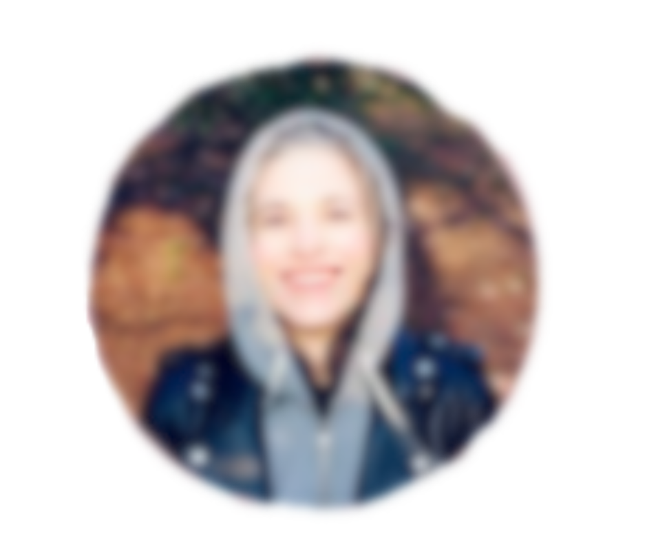 Blurry image of a person wearing a hooded jacket, smiling.