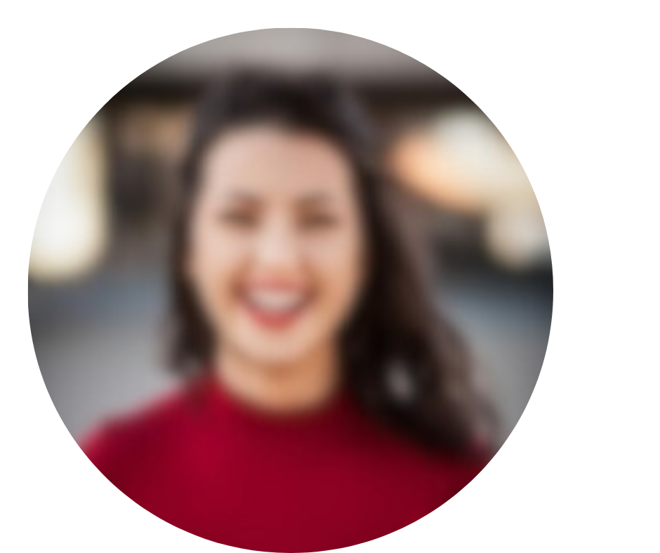 Blurred image of a person with long dark hair and a red top, smiling.