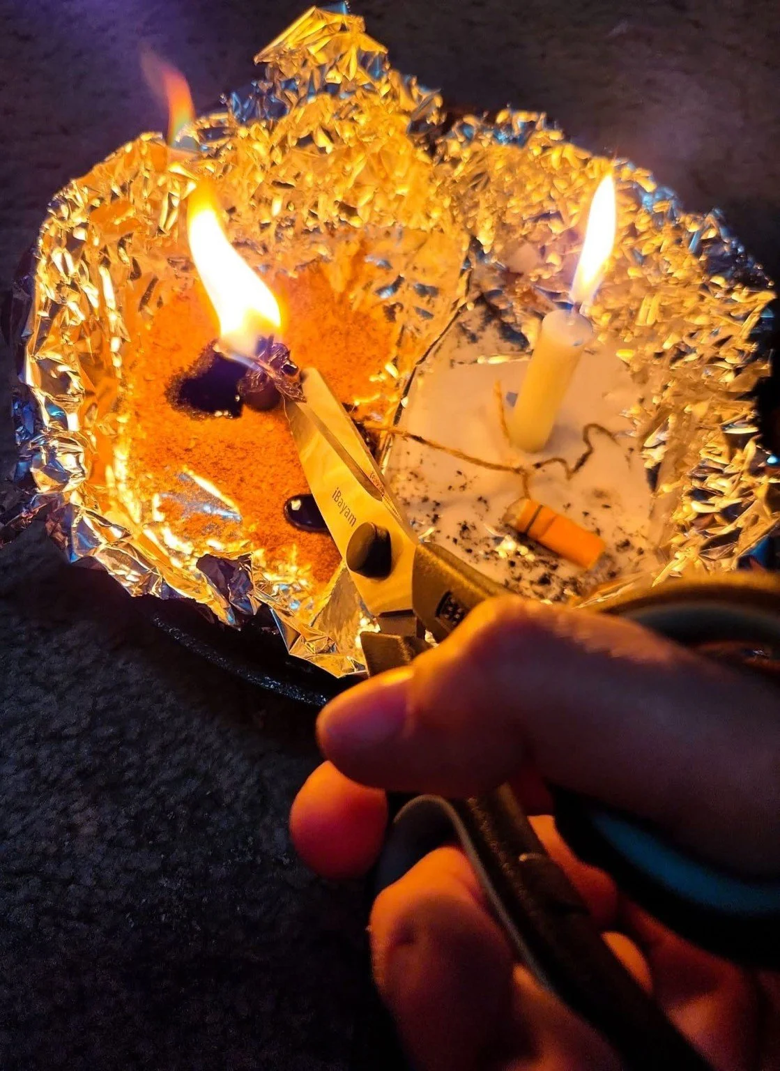 Cord cutting ritual with burning candles, cord, herbs, and fire for spiritual release and energetic separation.