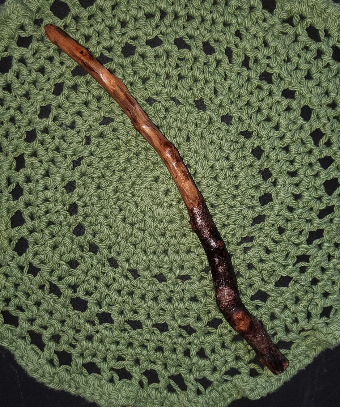 Wildwood Holler Wand #12, an Appalachian foraged wood ritual wand with a dark natural handle, warm polished upper body, natural knots, curved shape, and pointed tip.
