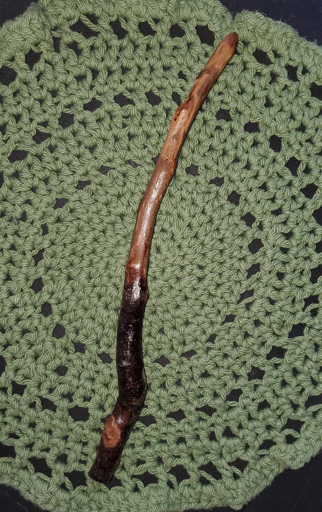 Wildwood Holler Wand #12, an Appalachian foraged wood ritual wand with a dark natural handle, warm polished upper body, natural knots, curved shape, and pointed tip.