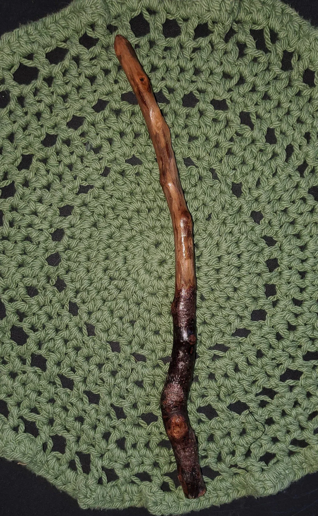 Wildwood Holler Wand #12, an Appalachian foraged wood ritual wand with a dark natural handle, warm polished upper body, natural knots, curved shape, and pointed tip.