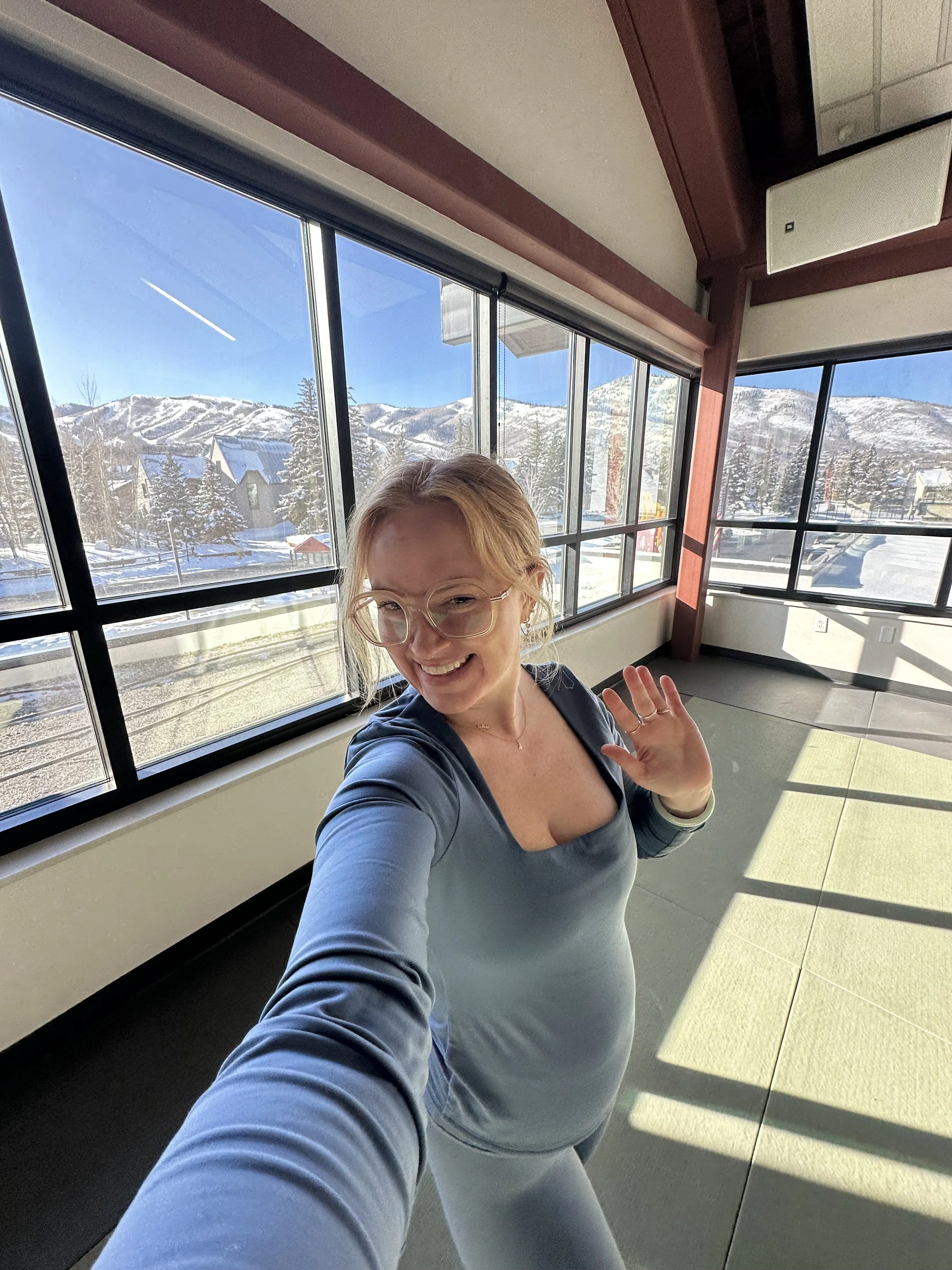yoga teacher in studio in front of mountains