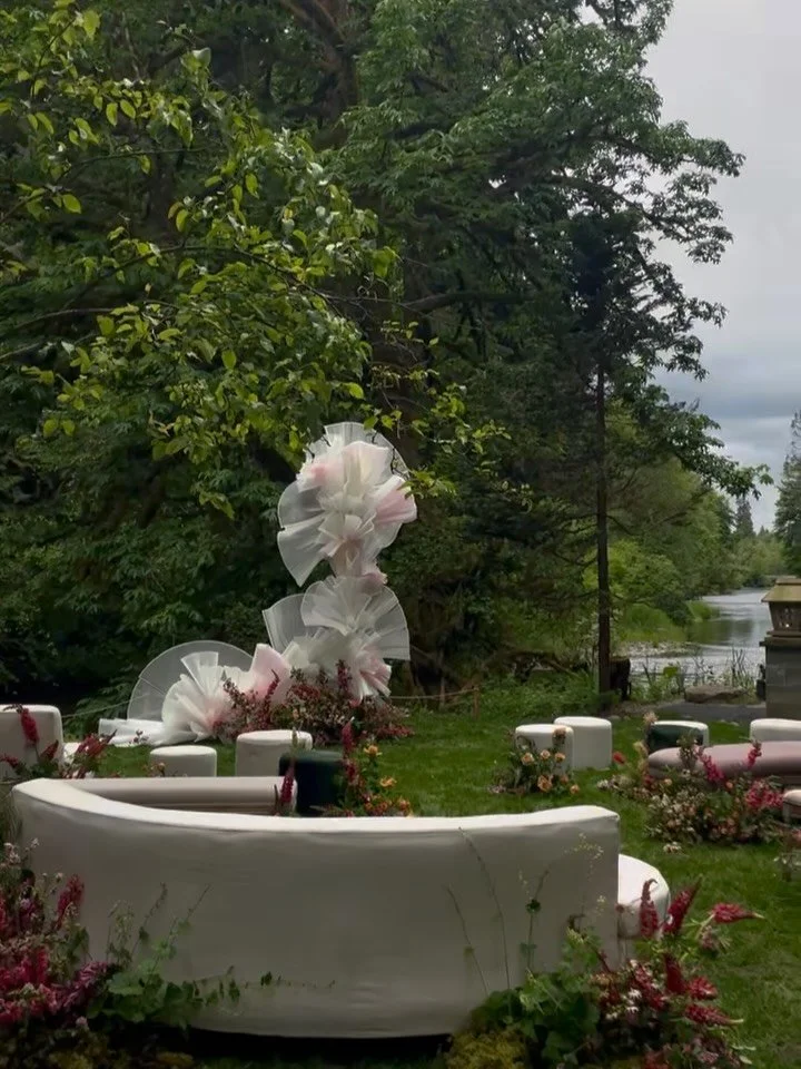 We love ceremony spaces that invite people to settle in, look around, and really be present. Soft fabric sculptural in place of a traditional arch, seating arranged naturally, and floral meadows grounding the space. These simple shifts make the cerem