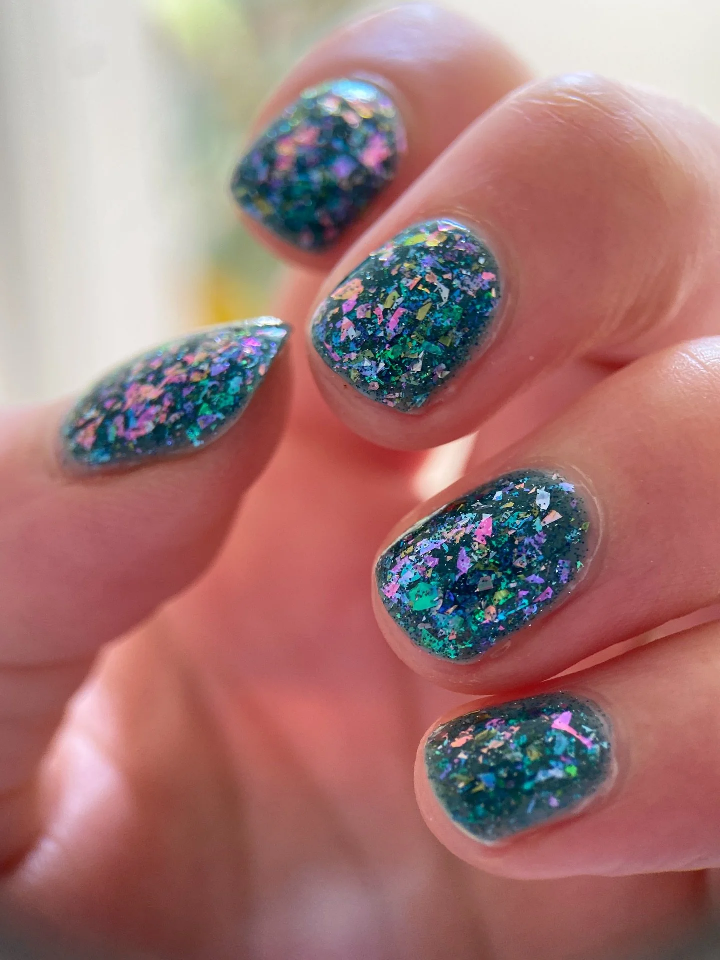 BLUE NYMPHEAS
Teal jelly base, teal/purple color shifting flakies, violet/pink/orange iridescent flakies, sage and pink holo flakes, blue reflective glitter

Swatched by @katie_scheid_art 
Paid PR

#fauvecosmetics #nailpolish #glitternails #tealnails
