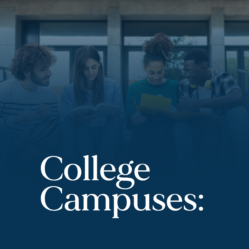 Four students sit together on college campus steps, reading and showing the importance of mental health programs for universities.
