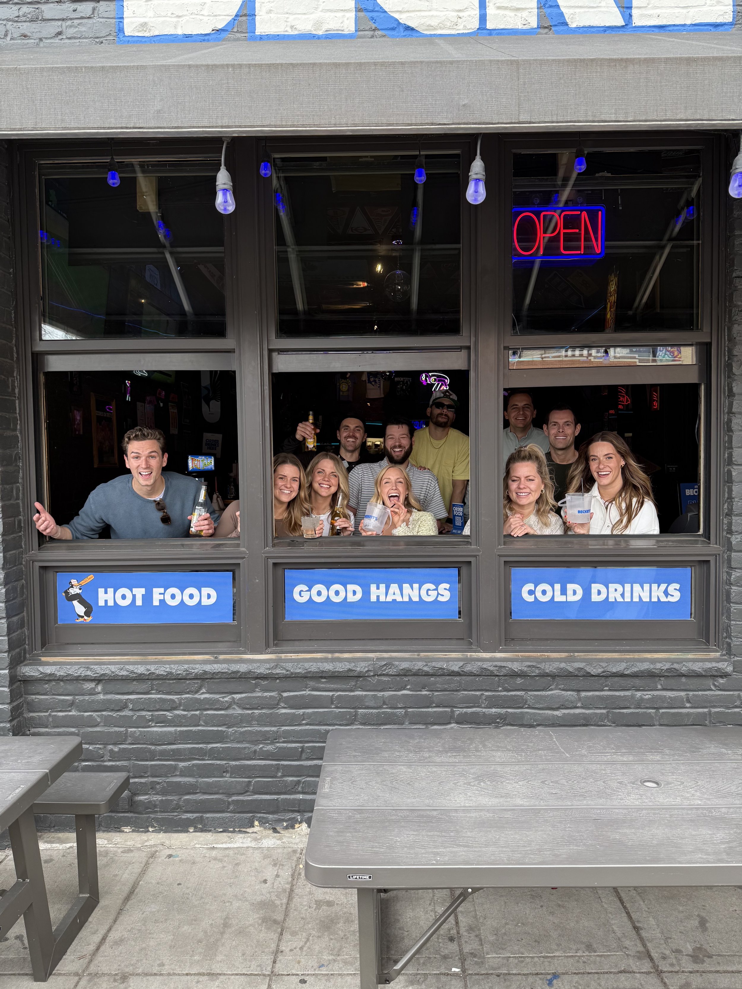 People having great time at sports bar hot food good hangs cold drinks