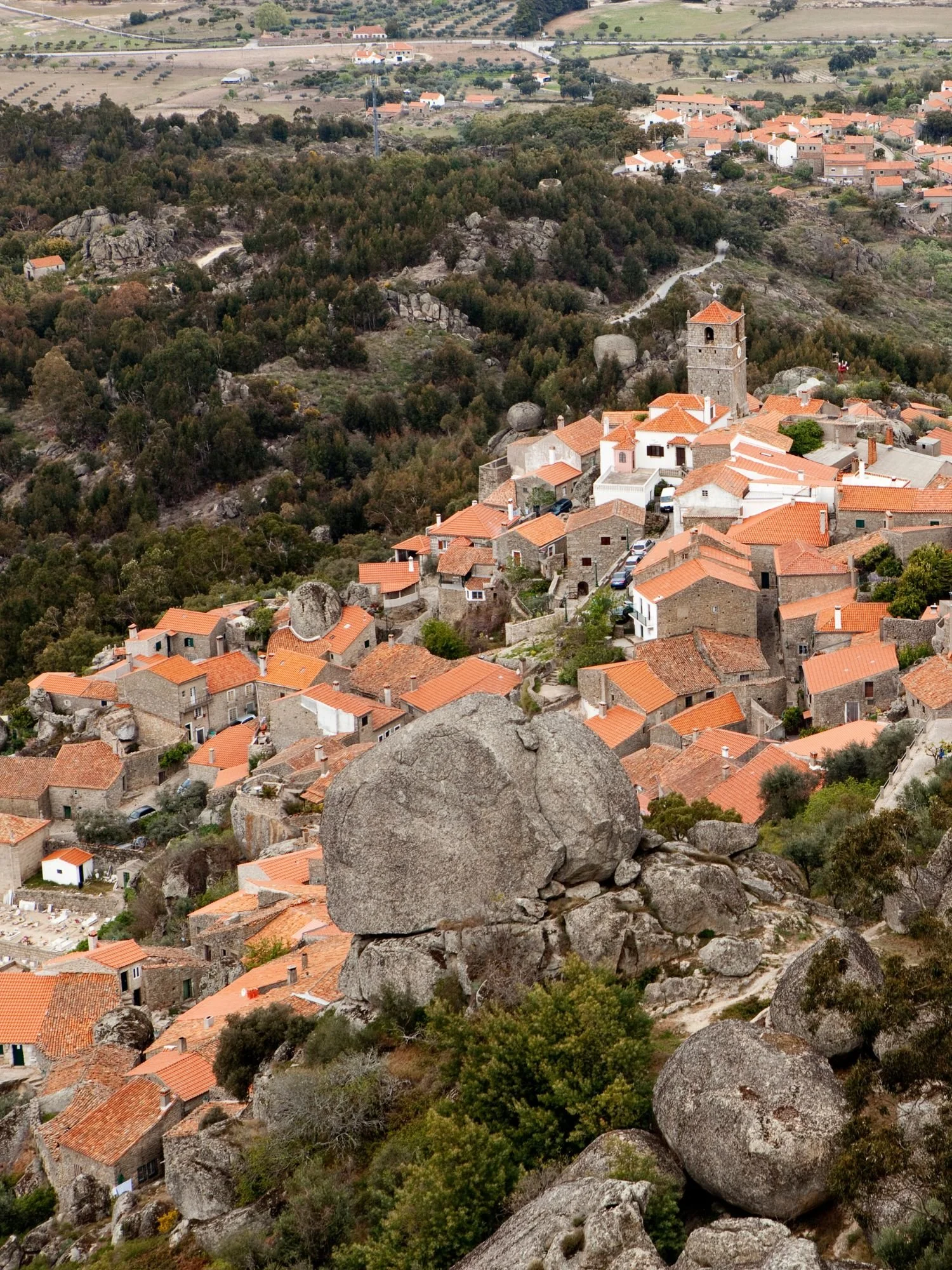 View over the village of Monsanto showing stone houses with terracotta roofs built among massive granite boulders, illustrating one of Portugal’s most distinctive historic villages integrated into a dramatic natural landscape.
